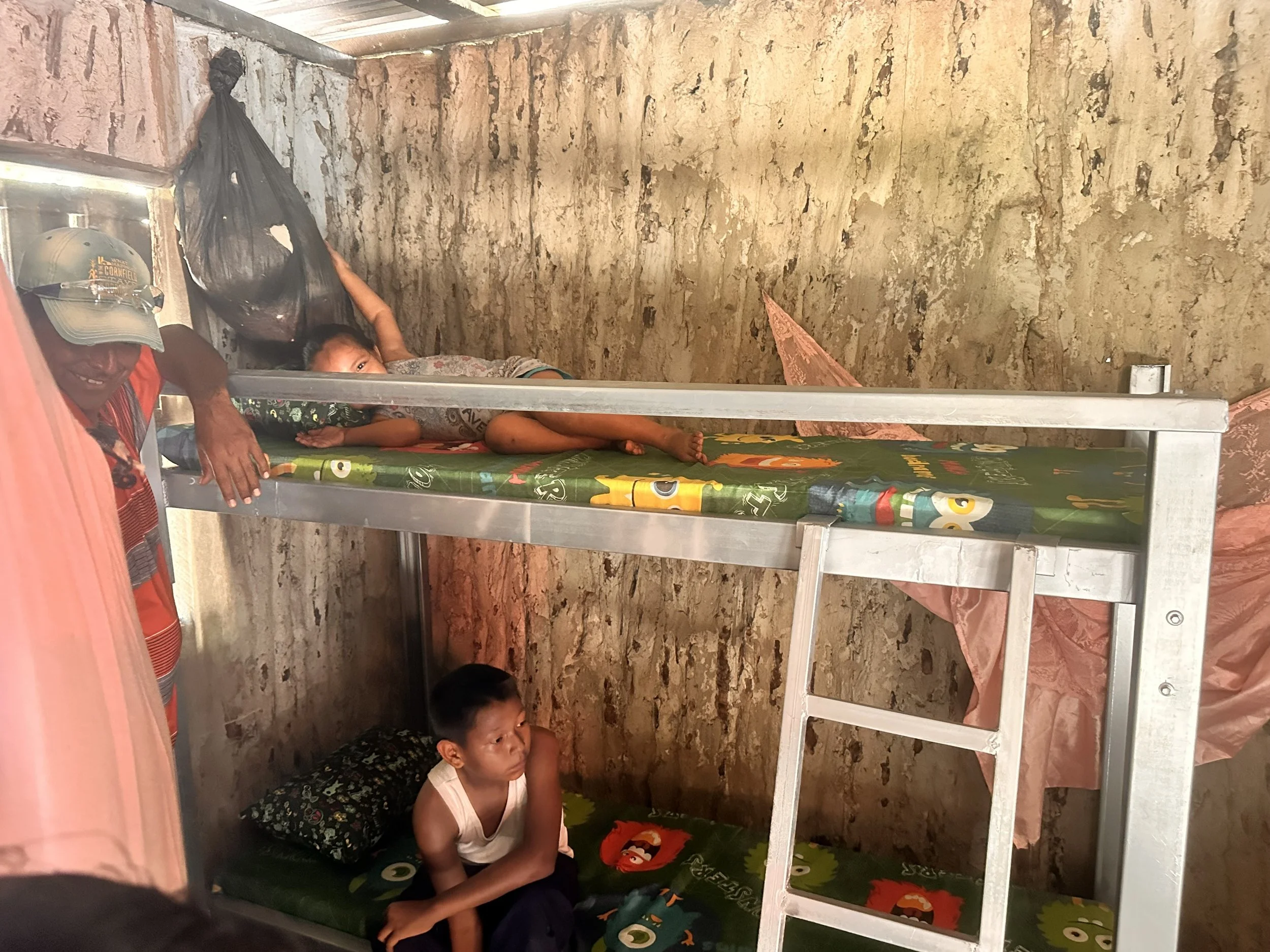 Children receiving a handmade bunk bed through True Belize's Christian community assistance ministry in Caledonia Village, Belize.