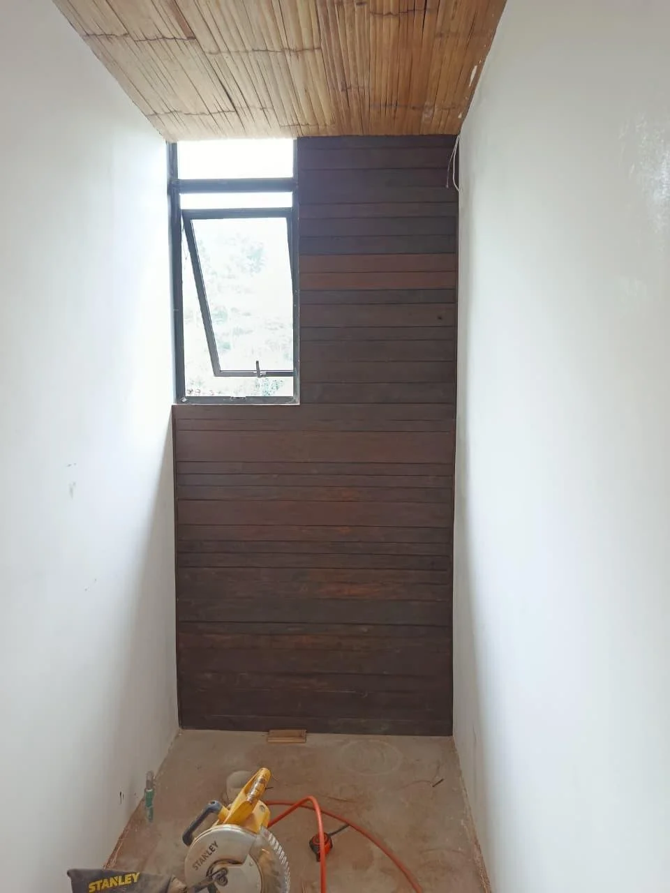 Construcción de una apred de madera con una ventana para una finca en Chiapas