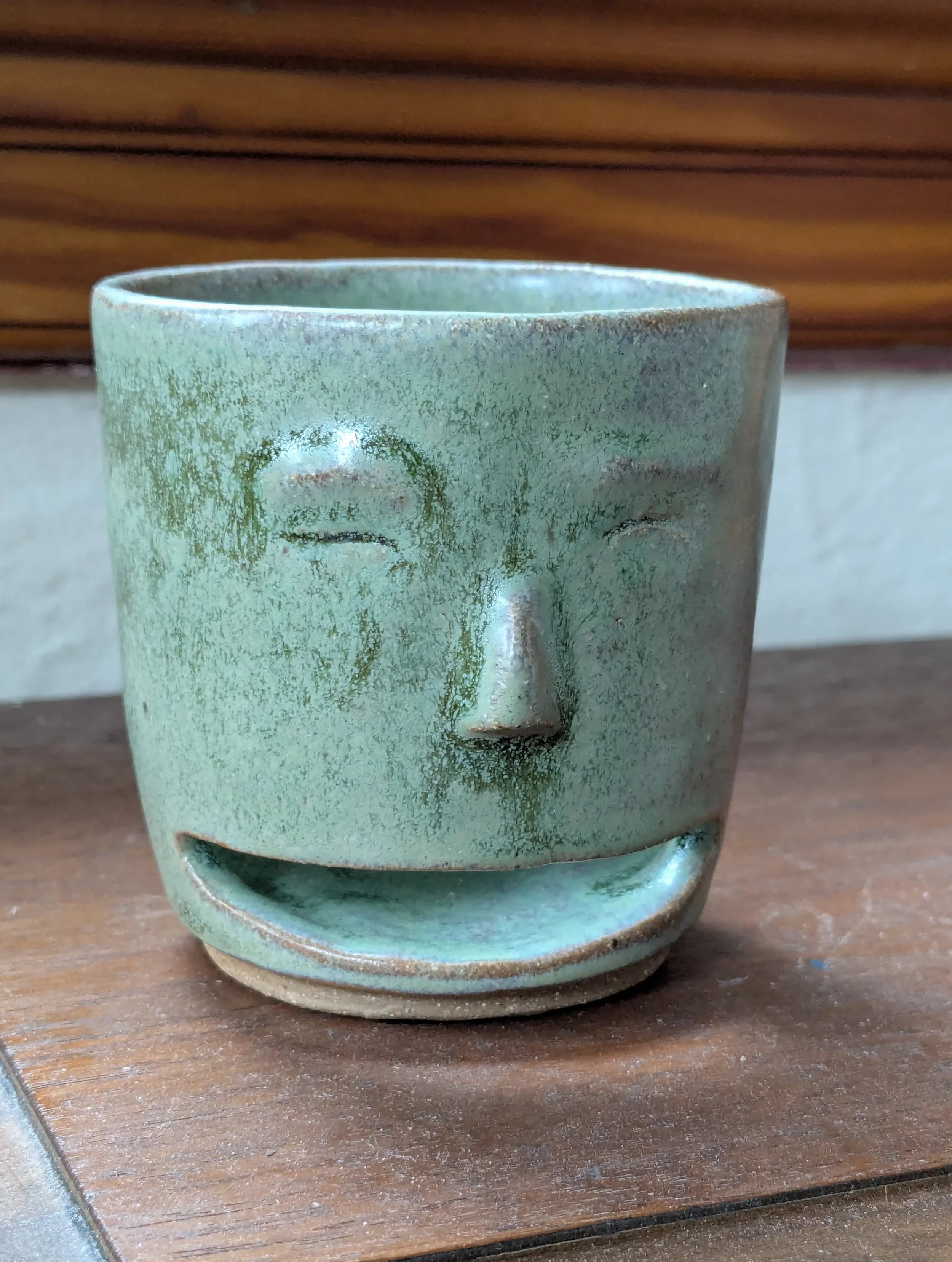 smiling green toothbrush holder.webp