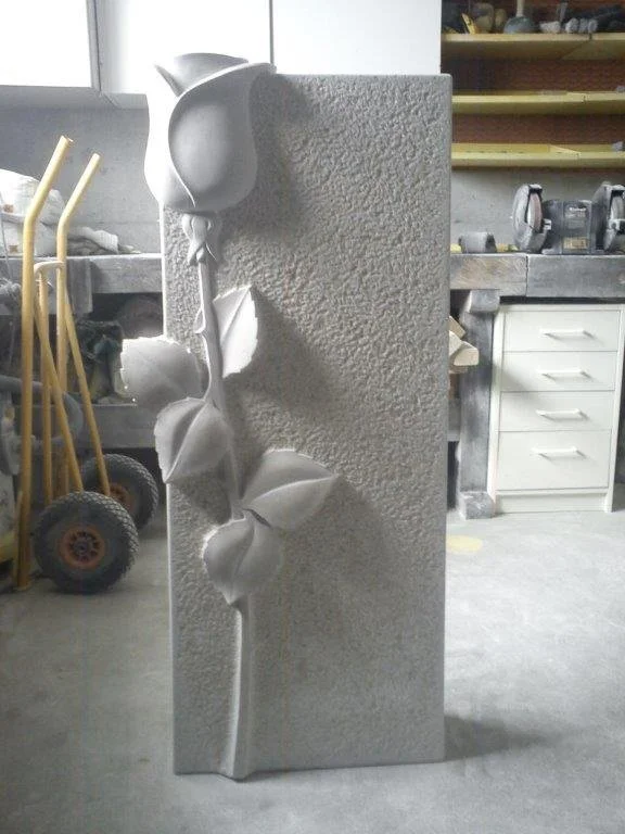 Steinerne Skulptur mit Rosenrelief im Werkstattraum