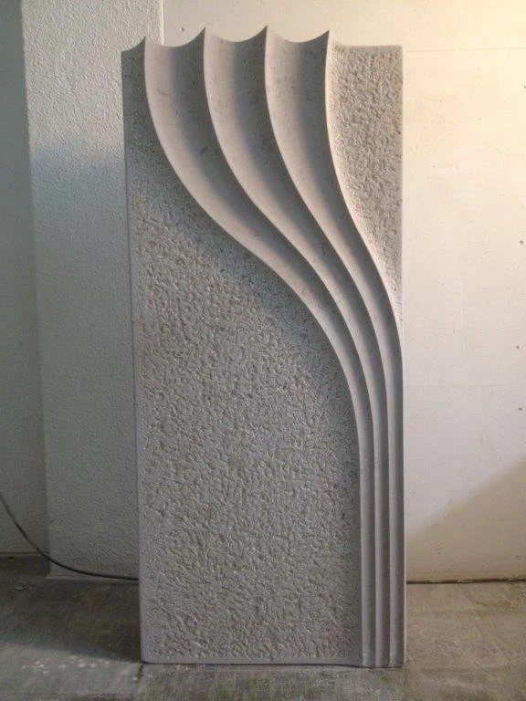 Skulptur mit gebogenen Linien vor einer Texturwandside