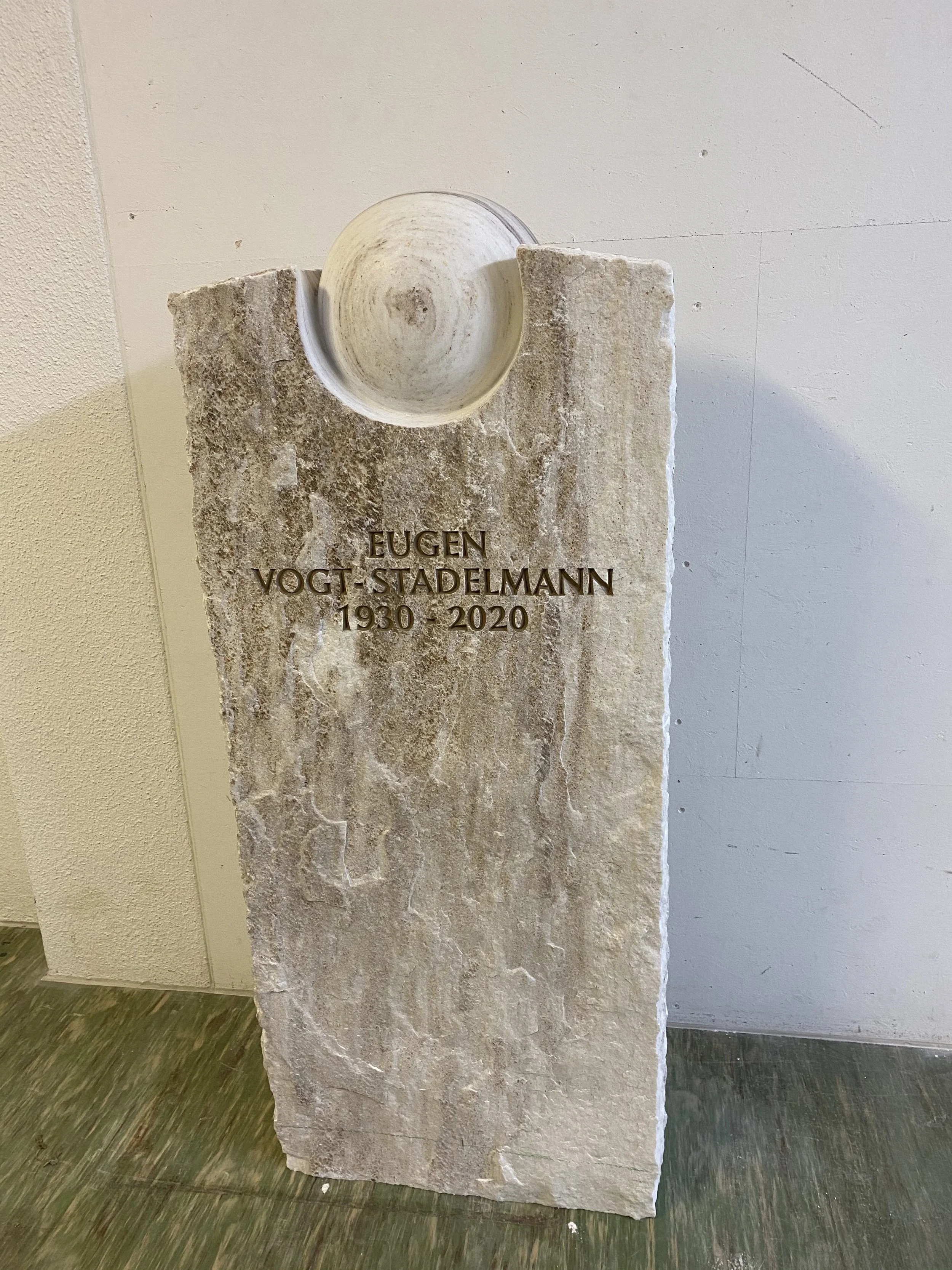 Gedenkstein mit einem weißen symbolischen Element an der Spitze, trägt die Inschrift: EUGEN VOGT-STADELMANN 1930 - 2020.
