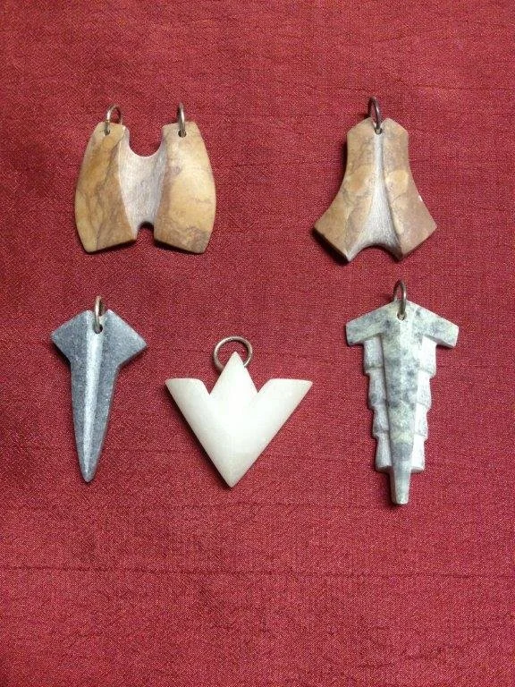 Fünf verschiedene L Bewaffnung Anhänger auf rotem Hintergrund.