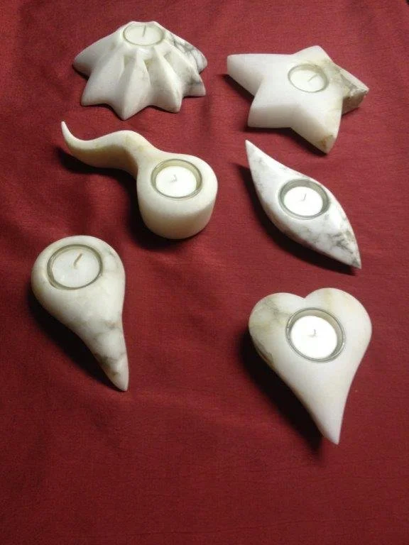 Kerzen in Form von Tier- und Sternmotiven auf rotem Stoff