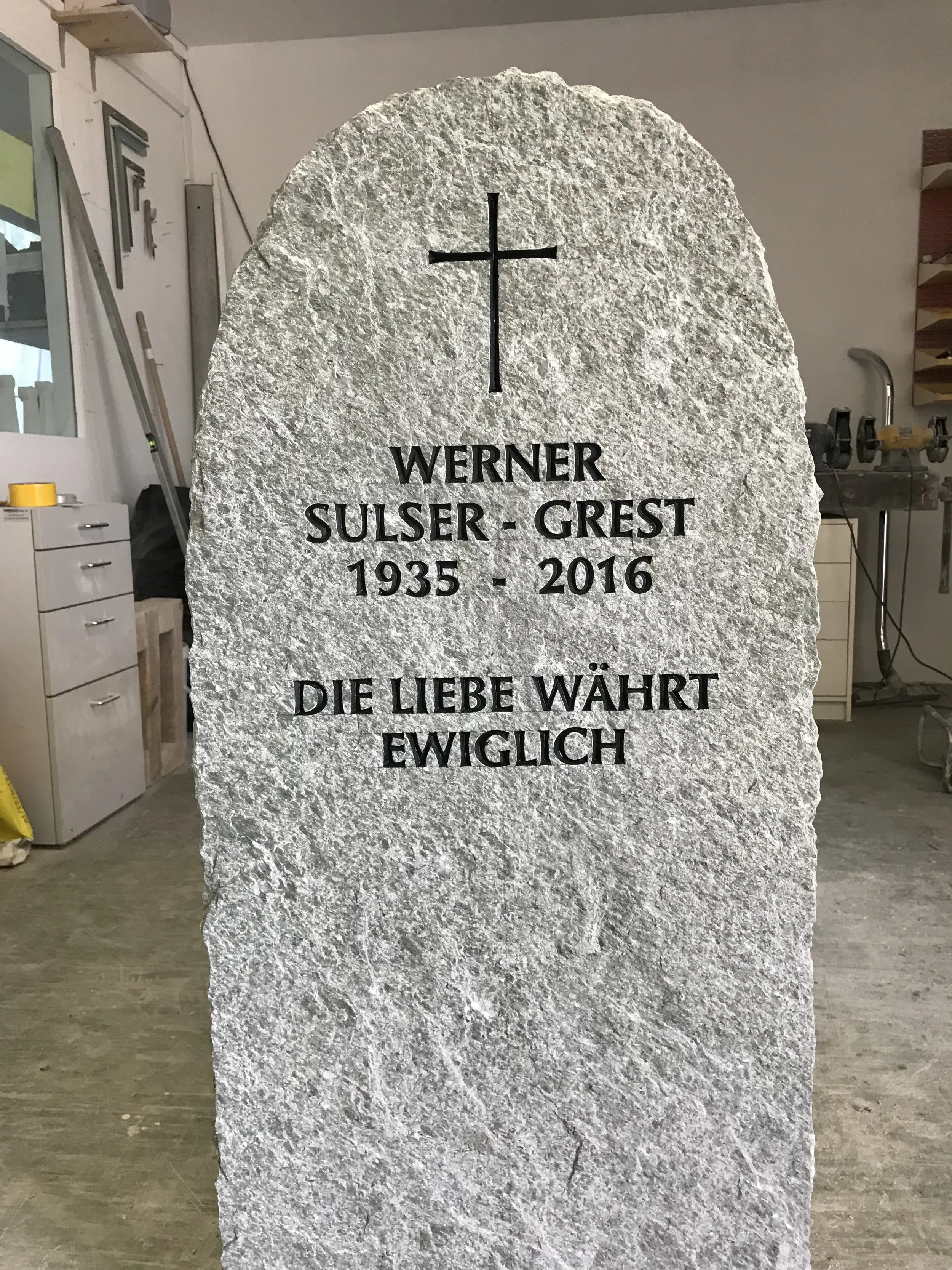 Grabstein mit christlichem Kreuz und deutscher Inschrift, die den Namen Werner Sulser-Grest, seine Lebensjahre 1935-2016 und das Zitat 'Die Liebe währt ewiglich' zeigt.