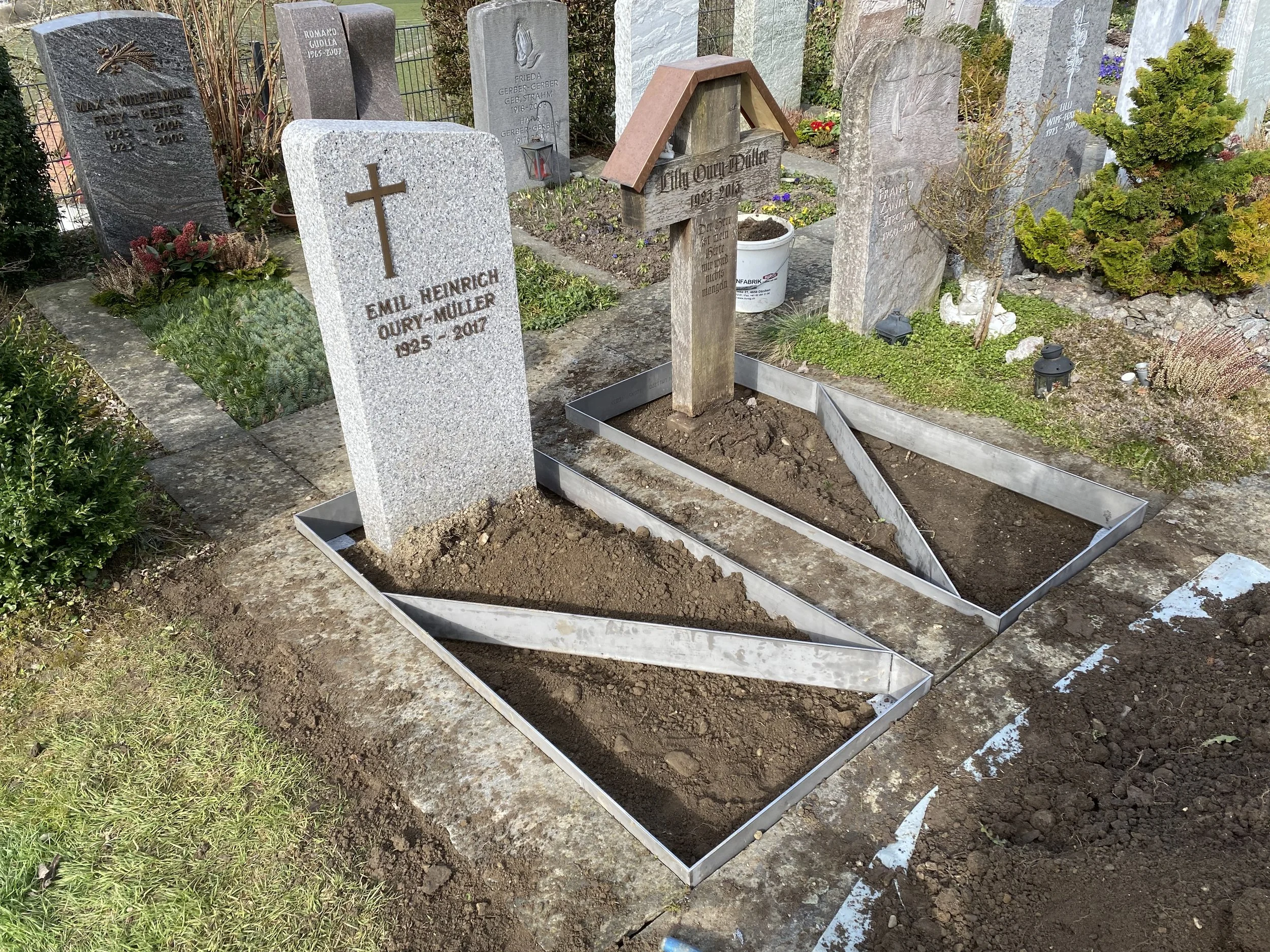 Vorbereitung der Gräber mit neuen Grabeinfassungen auf einem Friedhof, ein Grabstein for Emil Heinrich Oury-Müller, der 2017 gestorben ist, ist sichtbar.