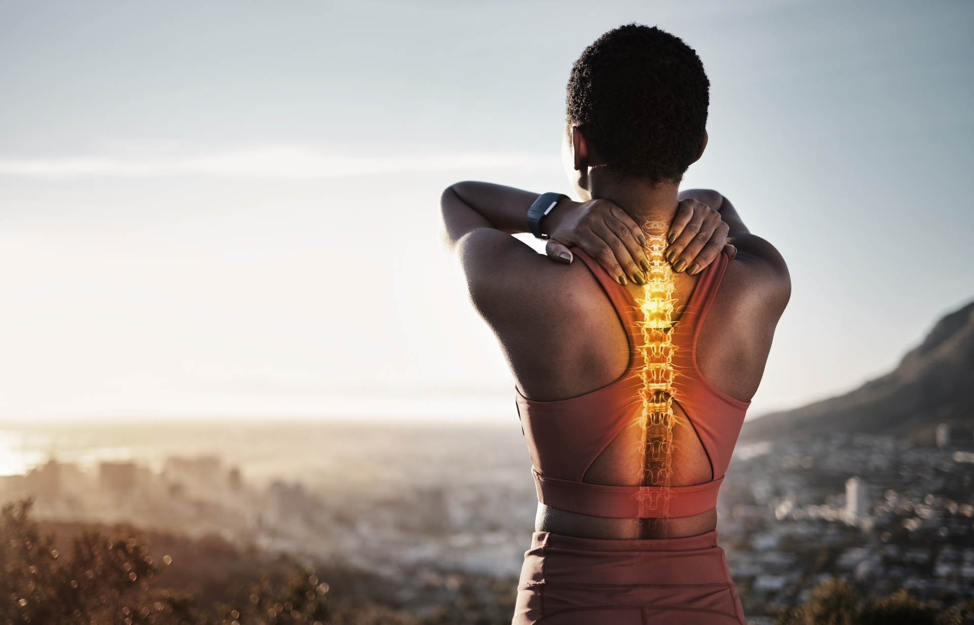 A woman stretching outdoors with a digital overlay of a glowing spine on her back.