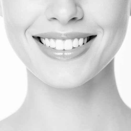 Close-up of a smiling woman's mouth showing her teeth.