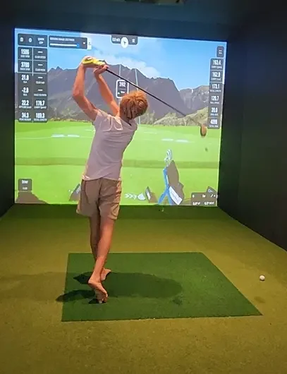 Rear shot of young man playing on the gold sim at Good Sport sports bar Napier.webp