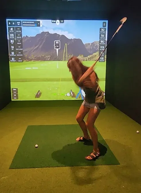Young woman playing on the golf sim at Good Sport sports bar Napier.webp