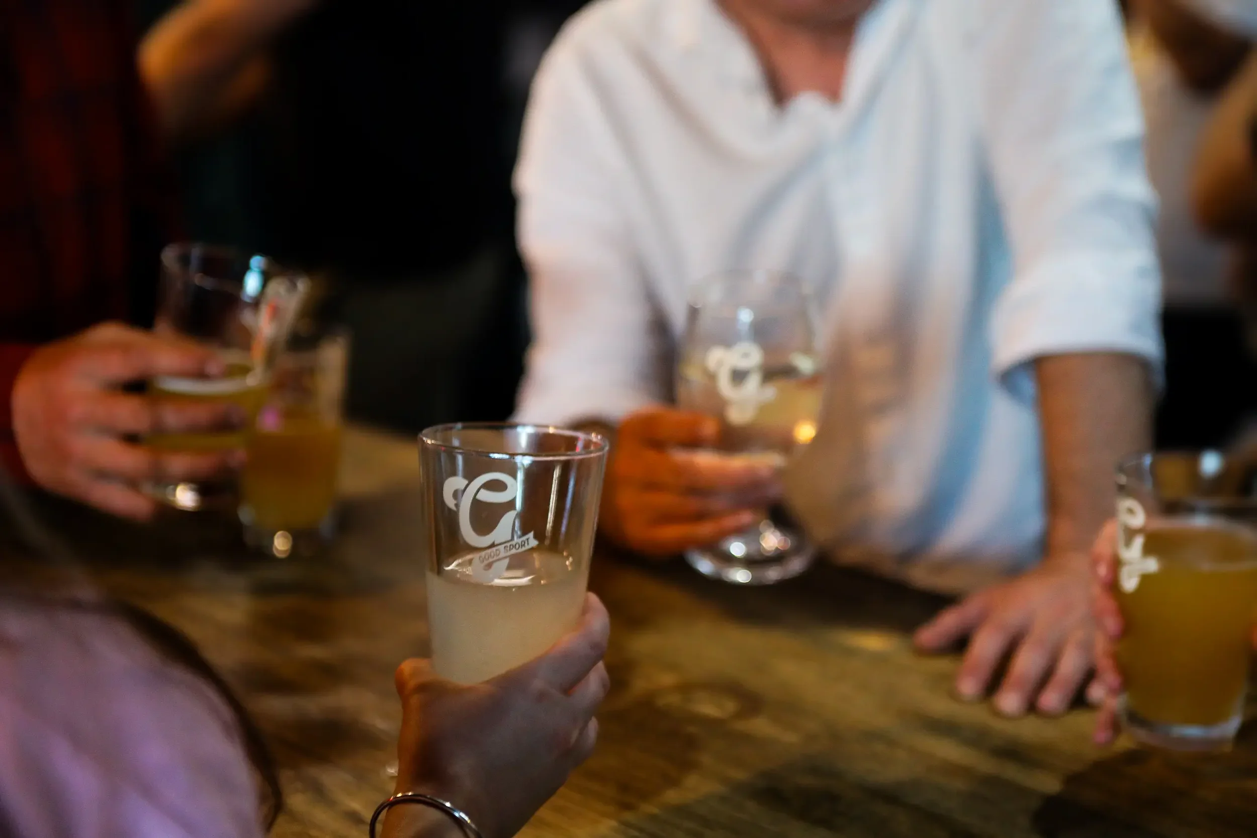 Friends sharing a drink at Good Sport.webp