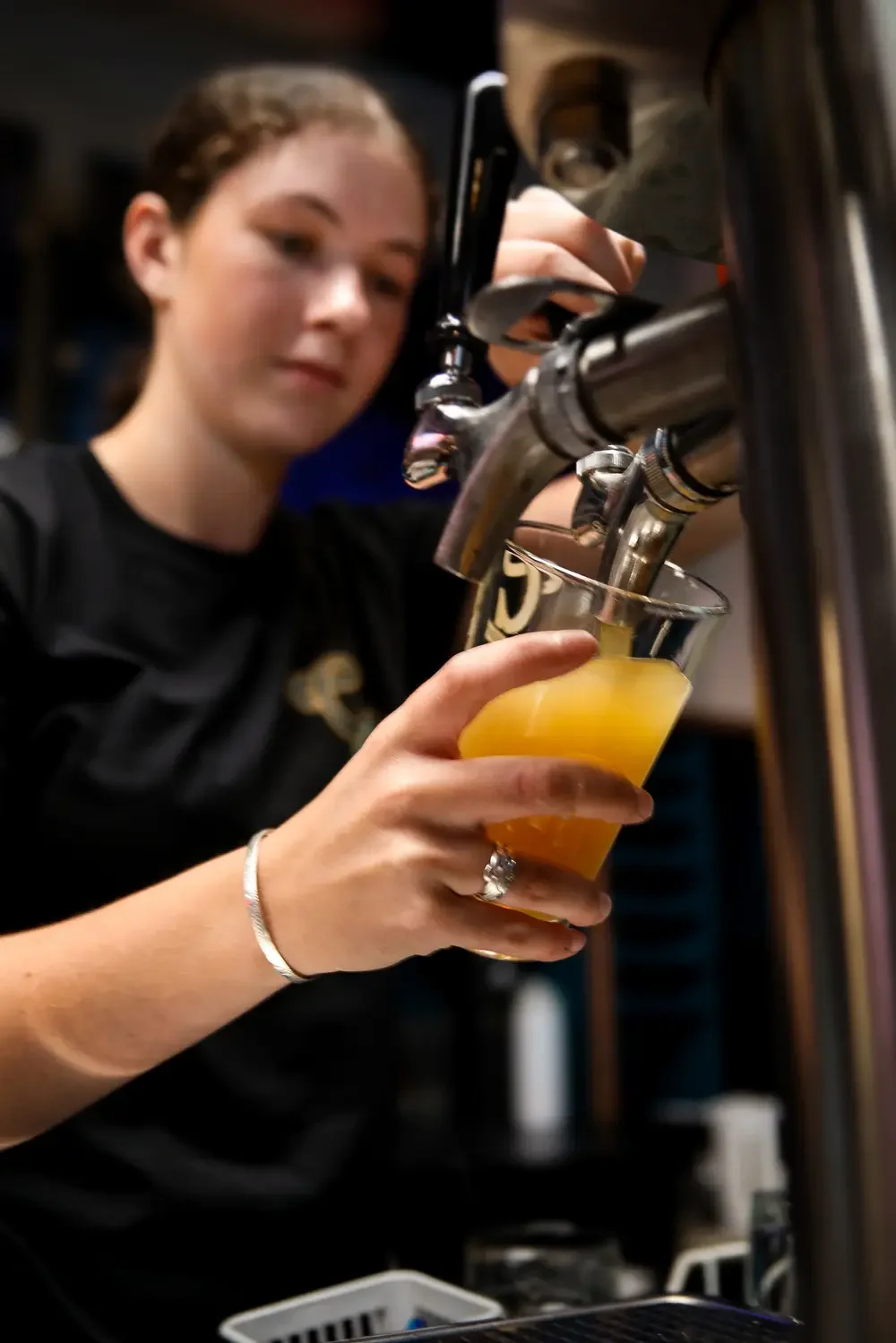 Server pouring a Good George beer.webp