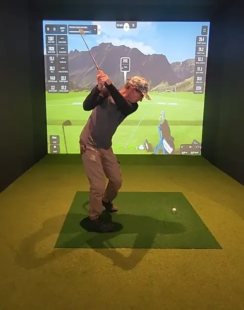 Young man with golf club in hand playing on the golf simulator at Good Sport sports bar Napier.webp