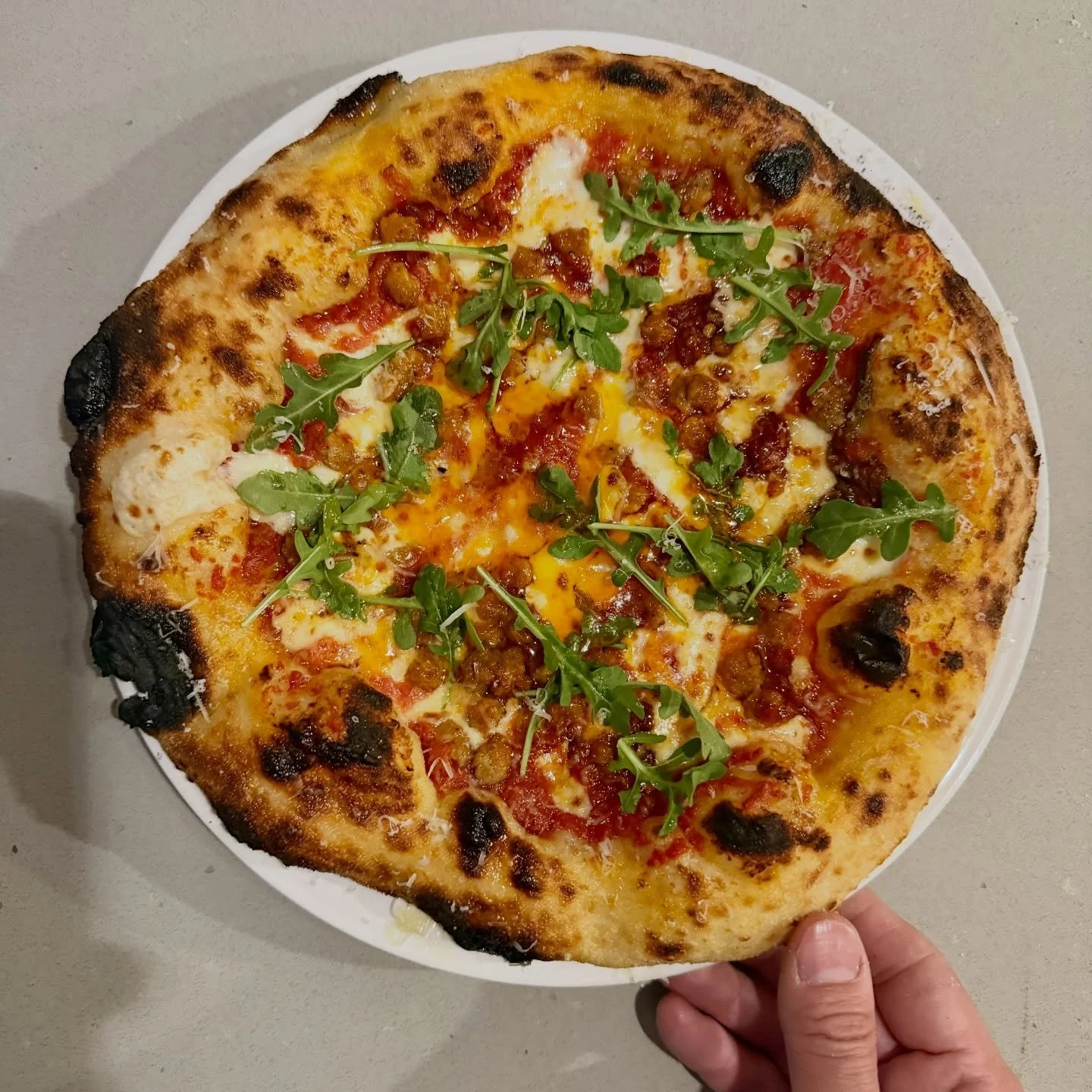 A custom pizza creation for a very special couple tying the knot this weekend in Carrboro. Made with 3-day fermented dough, fresh yeast, San Marzano tomatoes, Italian sausage, hot honey, Calabrian chili peppers, and arugula. #pizzawedding #carrboro #