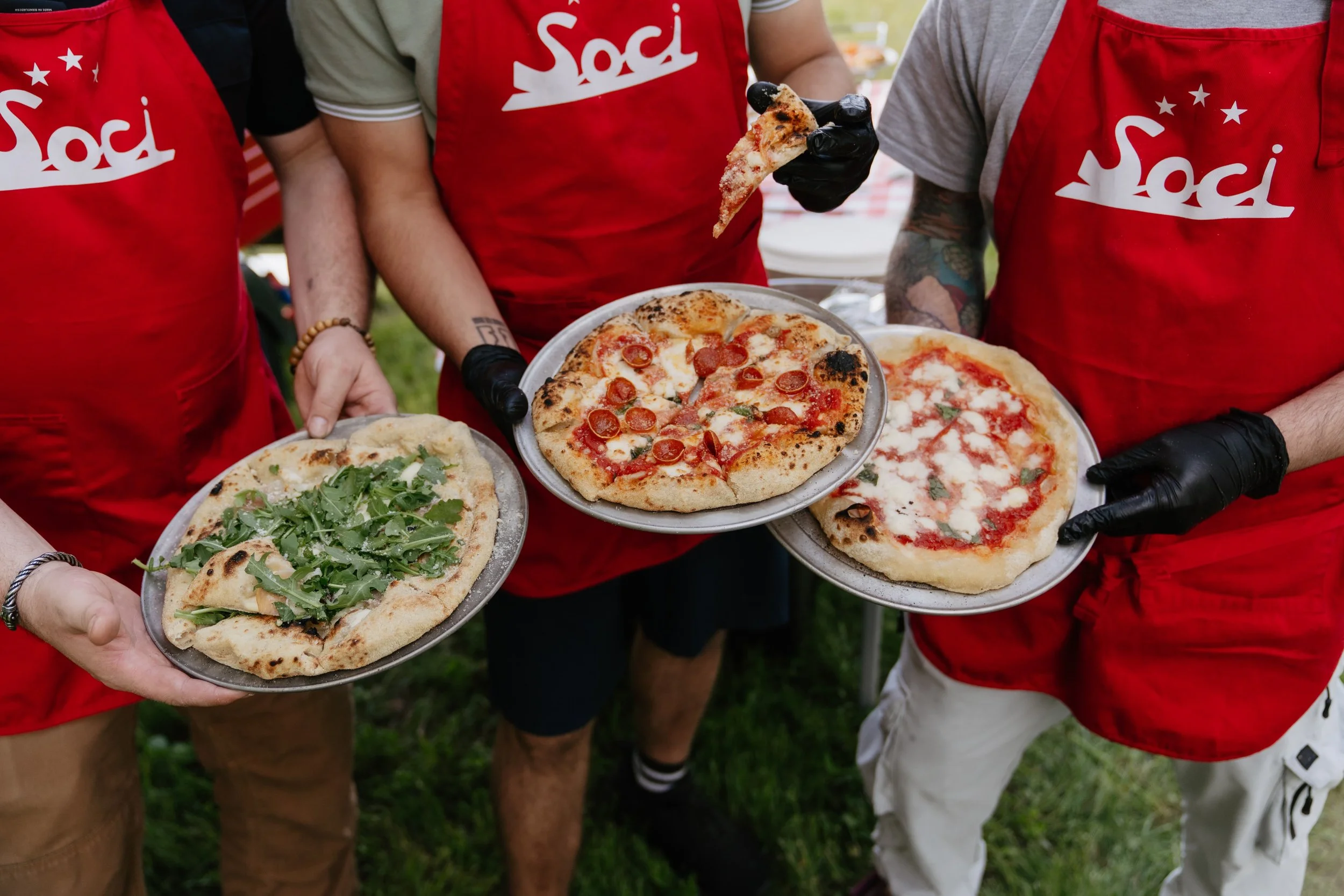 Three men holding 3 pizzas from Soci Pizza in Raleigh, NC.