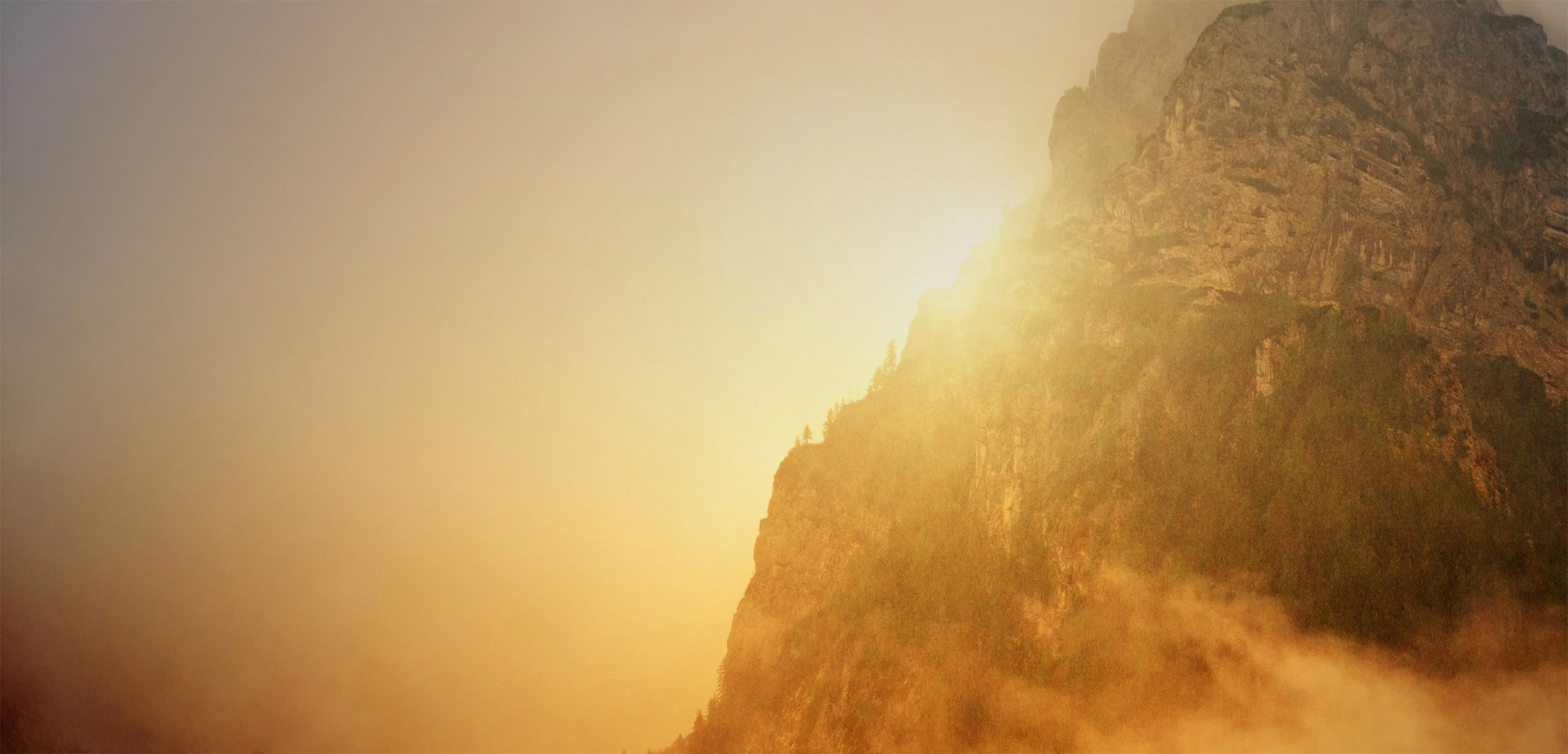 Light shining from behind a mountain