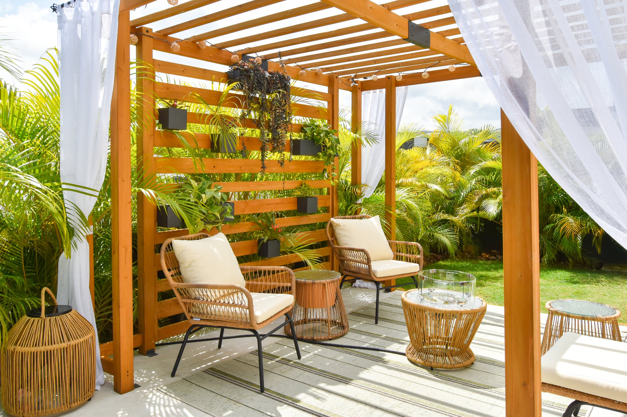 Defined outdoor living zones with seating and greenery in a modern Jamaican landscape design.