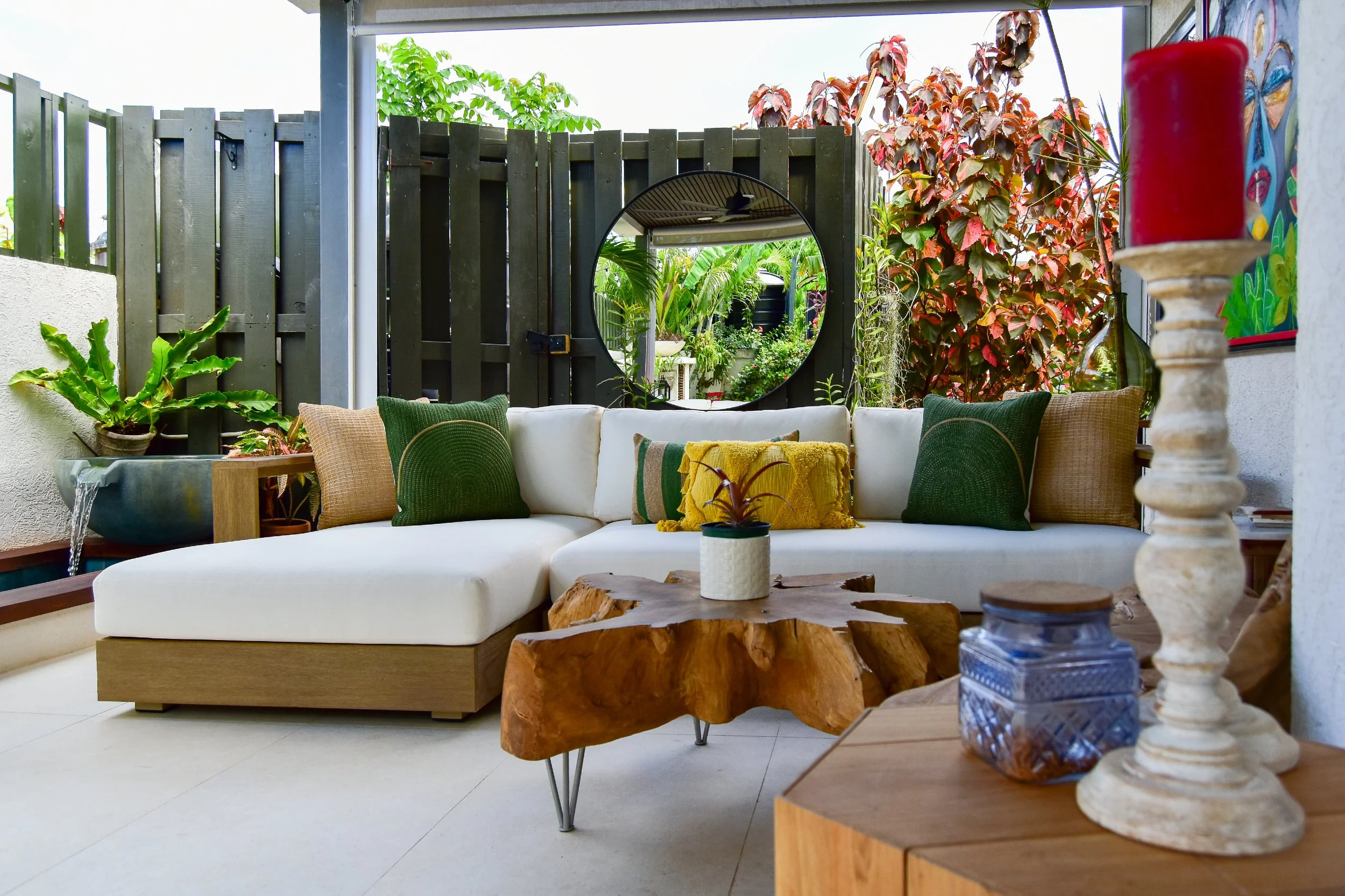 Modern outdoor living lounge with custom sectional seating, tropical greenery, water feature, and natural wood accents designed by AurumScape in Ocho Rios, Jamaica
