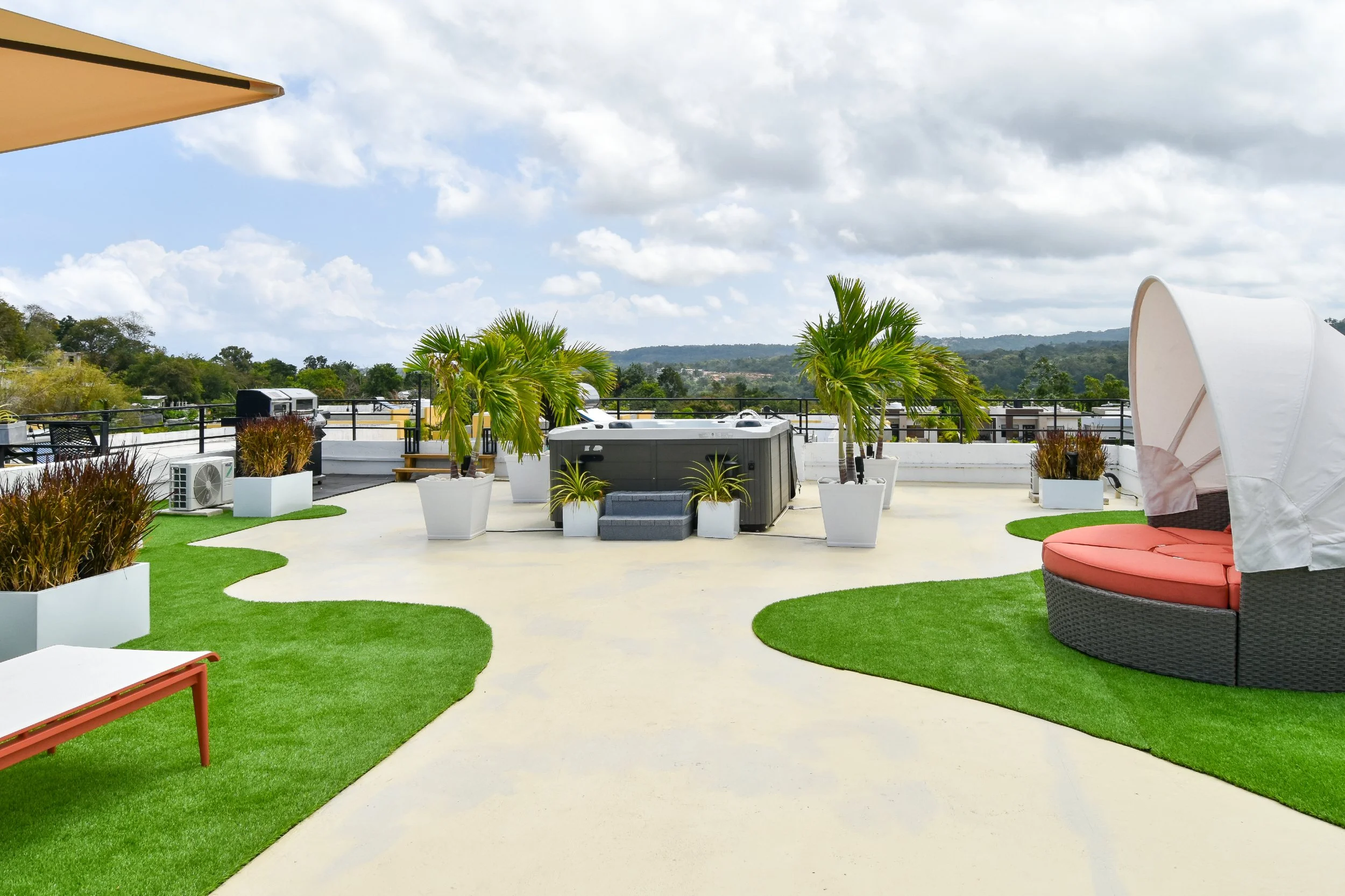 Modern rooftop design featuring a curated outdoor living terrace with tropical plants and contemporary seating, designed in Jamaica.