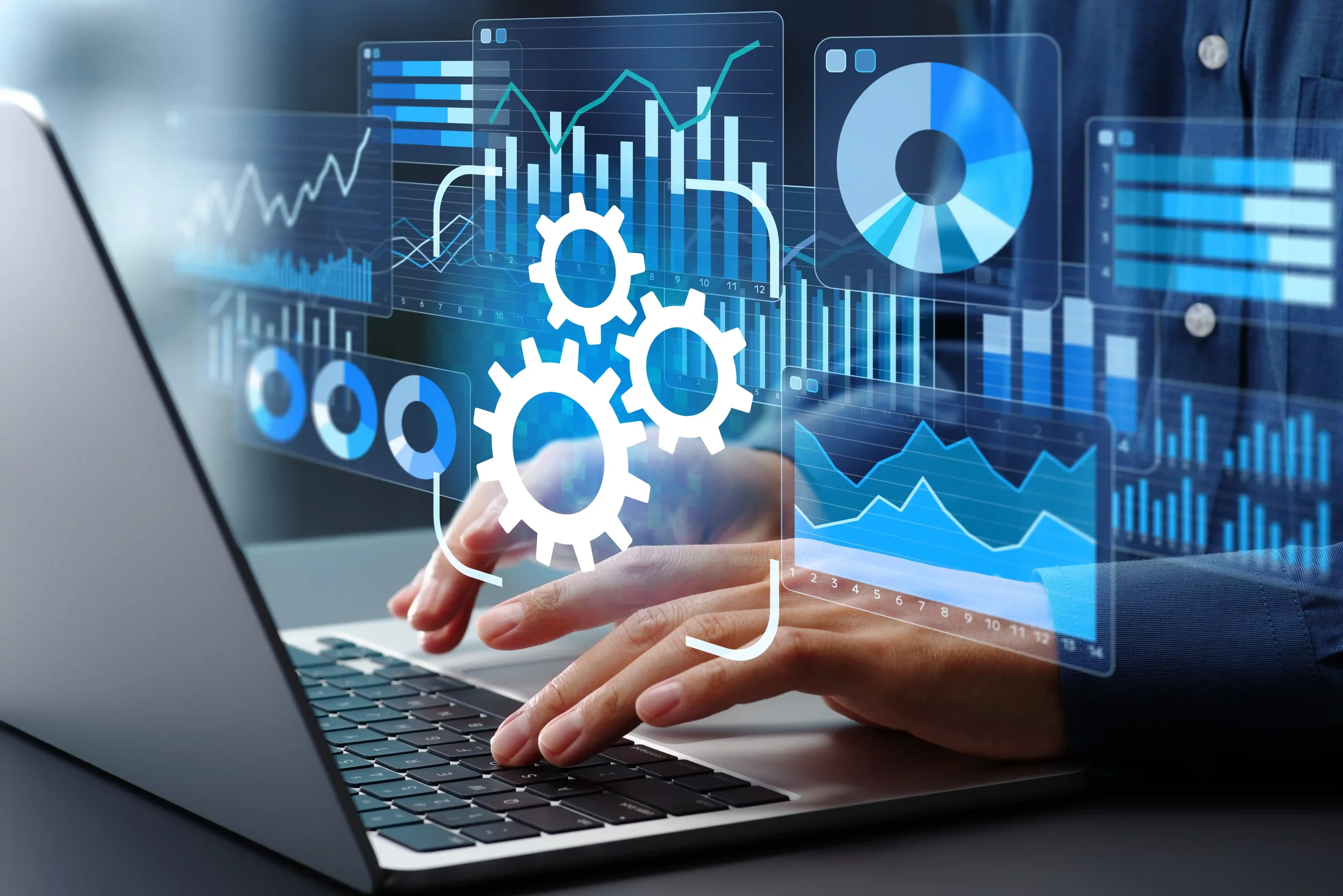 Person using a laptop with digital graphs, charts, and gear icons overlayed, representing data analysis or technology.