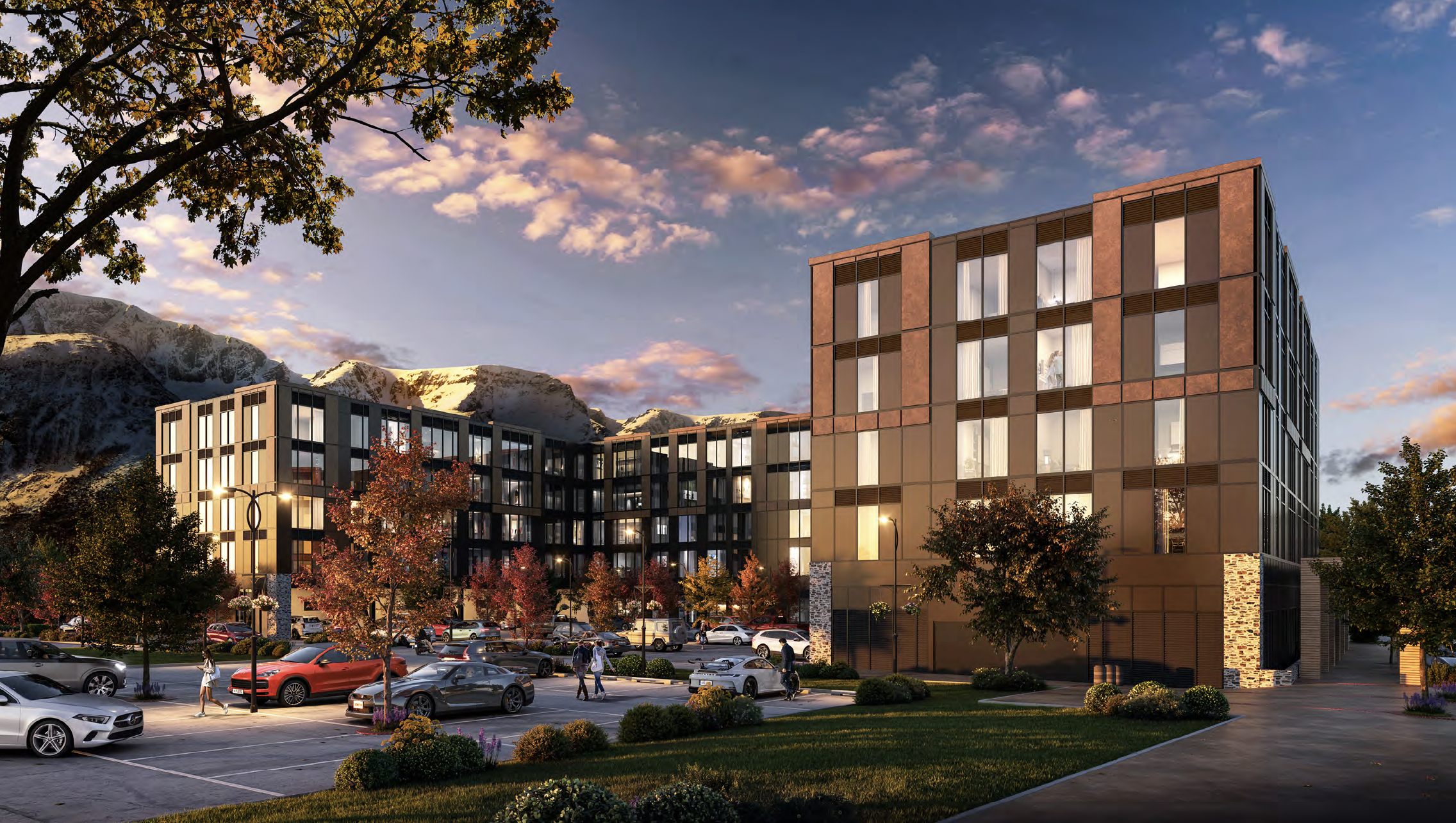 Mountain Oak Apartments Modern apartment complex at sunset with mountains in background, parking lot with cars, and autumn trees in the foreground. Grantham Group Project