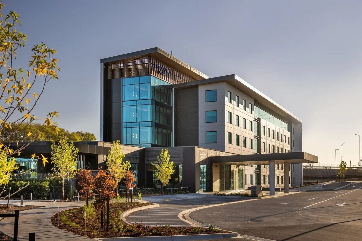 Double Tree Karaka Modern multi-story office building with glass windows and landscaped parking lot. Grantham Group Project