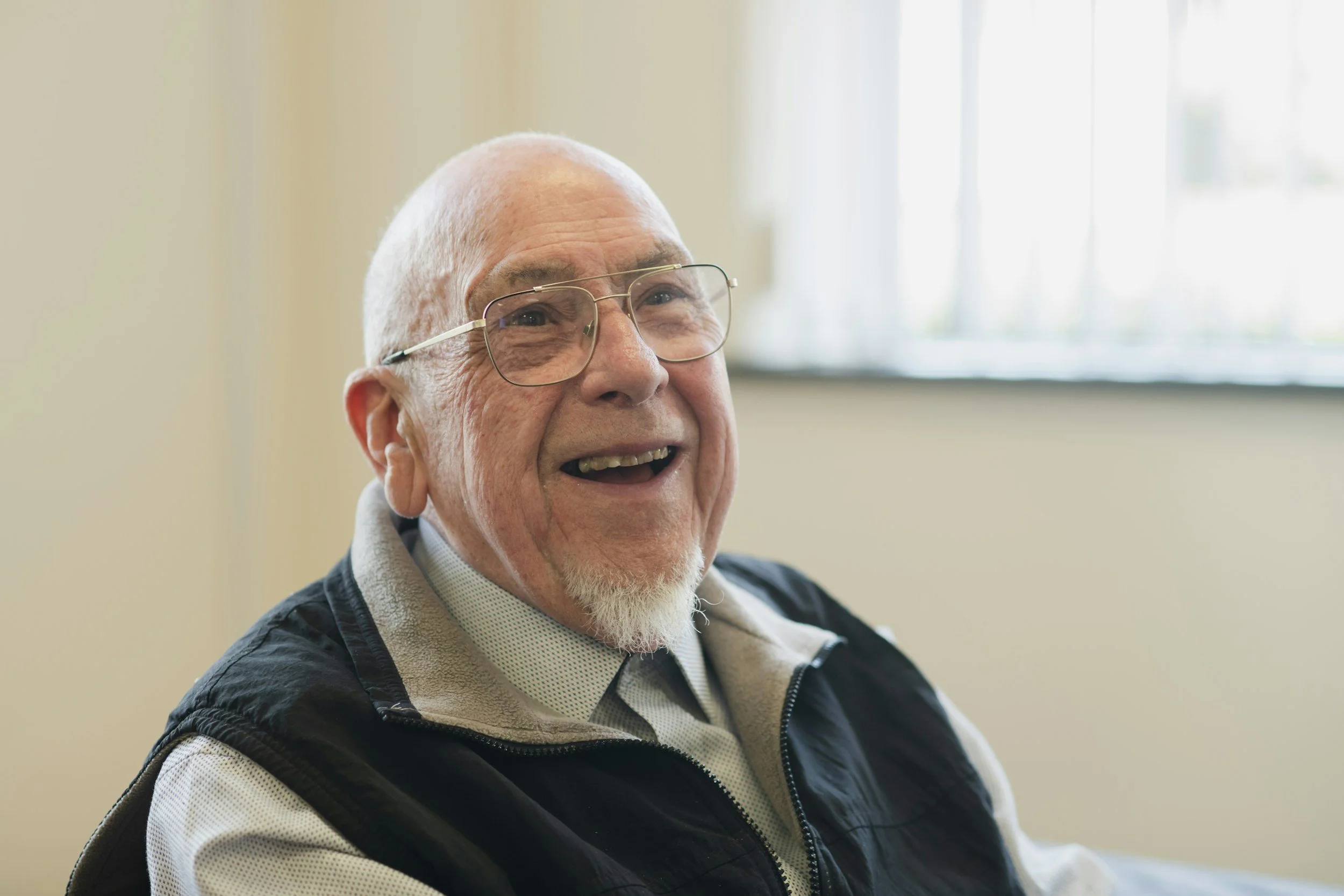 Old man wearing glasses and smiling