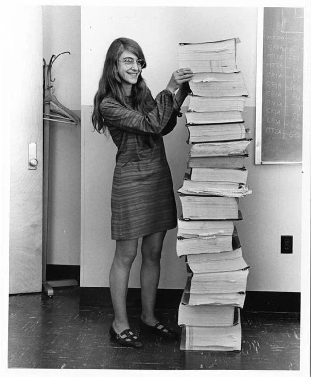 Margaret Hamilton, NASA’s lead developer for Apollo program, stands next to all the code she wrote by hand that piloted the historic trip to the moon in 1969.