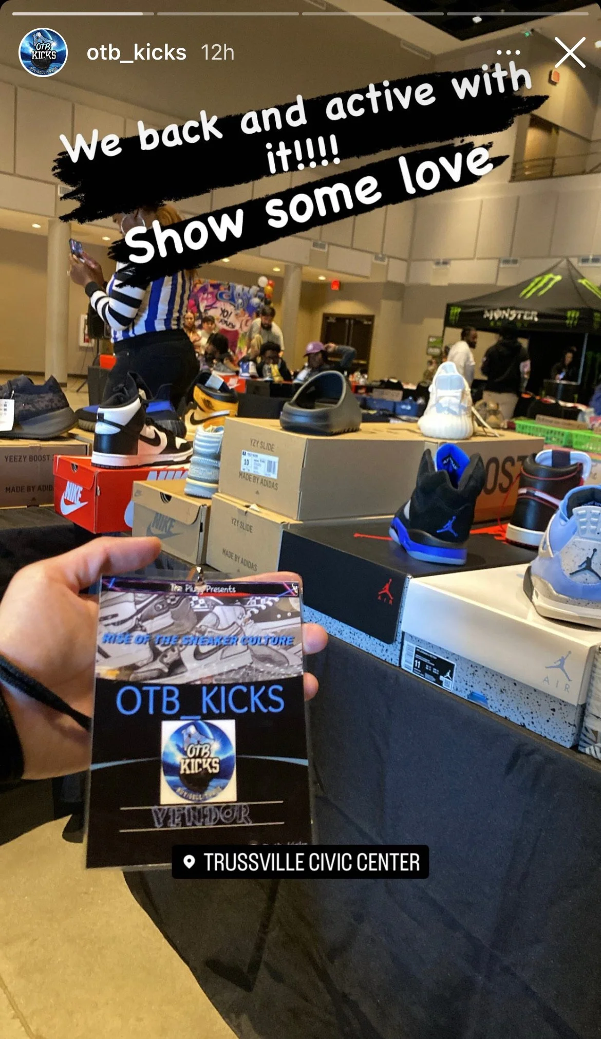 A person holding a ticket for OTB_KICKS, an event at Trussville Civic Center, with a table of sneakers and shoe boxes behind them at an indoor sneaker event.