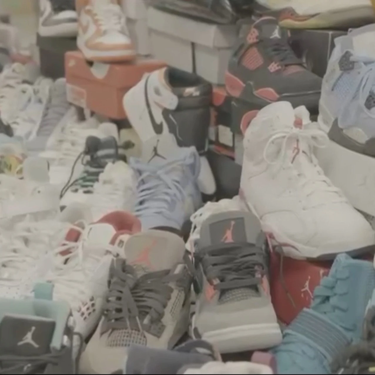 A collection of various sneakers and shoe boxes displayed on a surface, including Nike Air Jordans and other athletic shoes in different colors and styles.