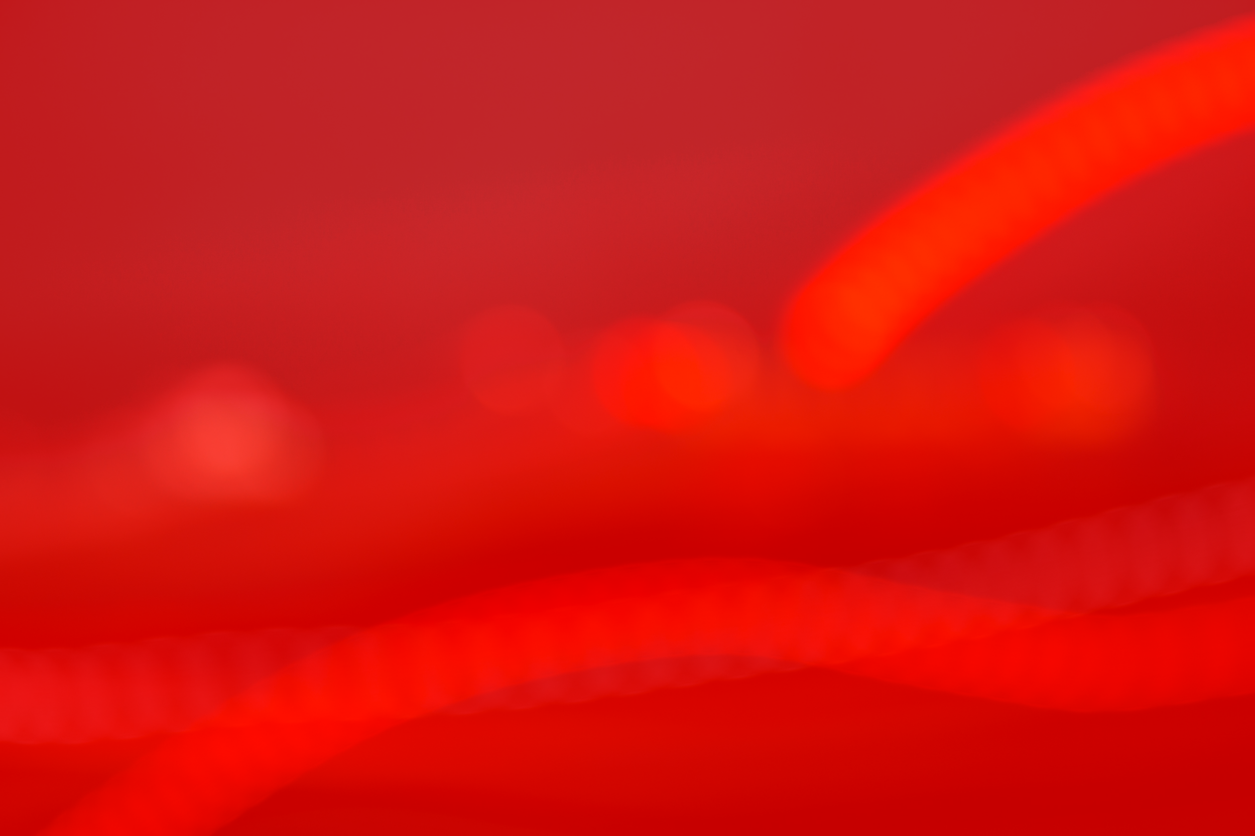 An abstract image with red tones, featuring bokeh light spots.