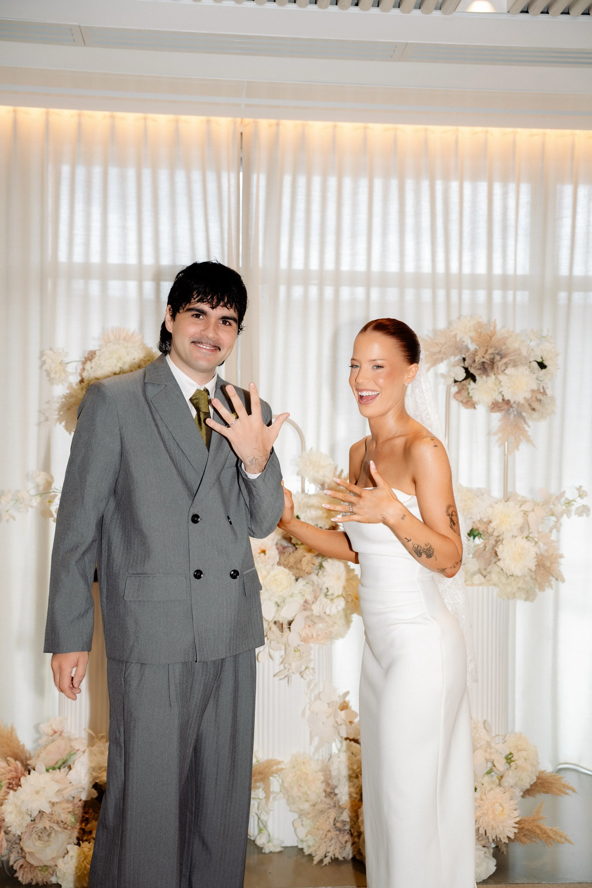 Couple showing their wedding rings and smiling after the ceremony