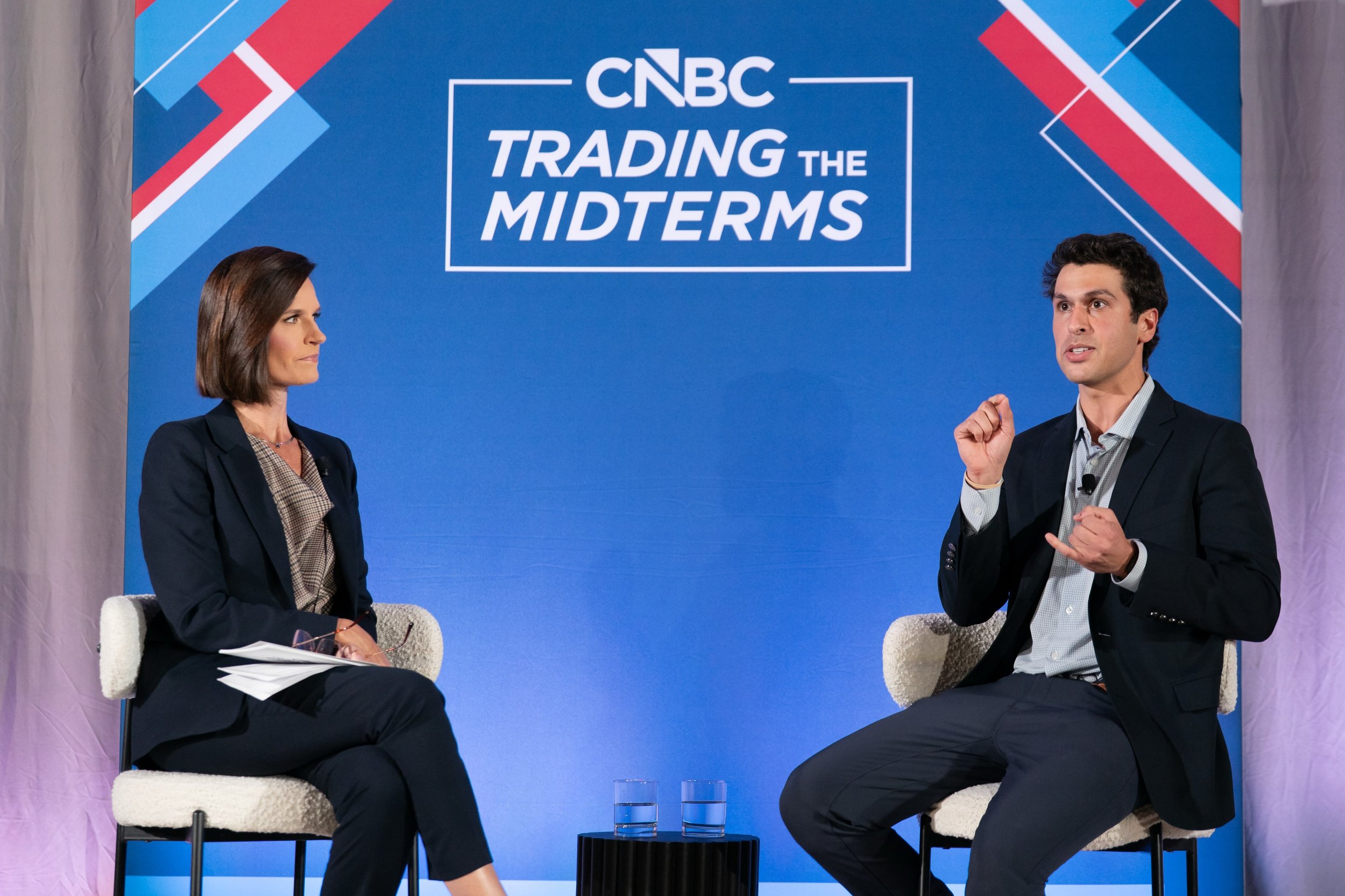 Contessa Brewer interviewing a guest on stage at CNBC Trading the Midterms