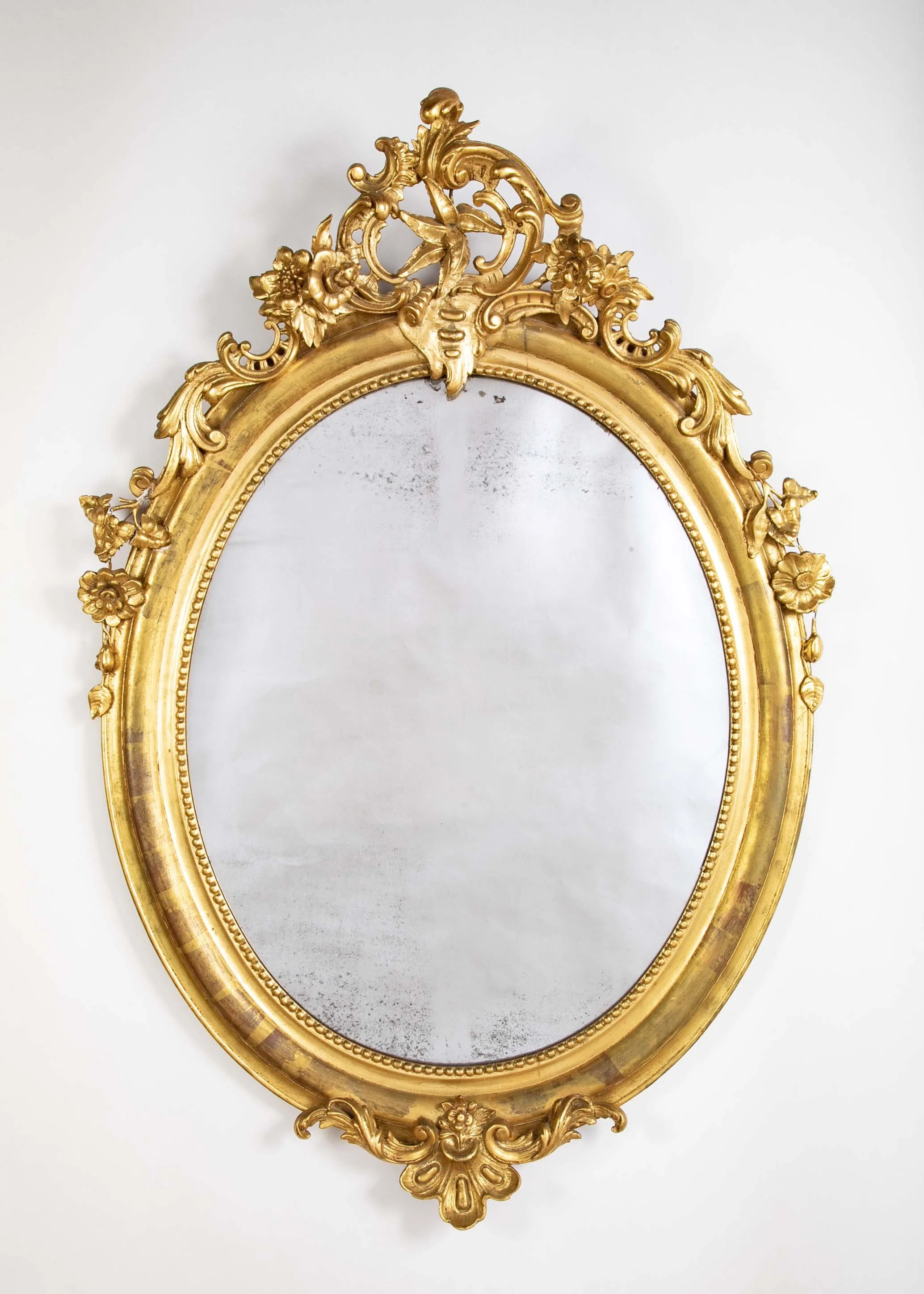An 18th century French carved and gilt oval mirror from Bordeaux.  54" h x 32" w 