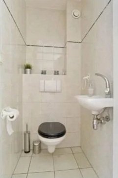 Modern white house with large glass sliding doors, a swimming pool, and a balcony with glass railings under a clear blue sky.