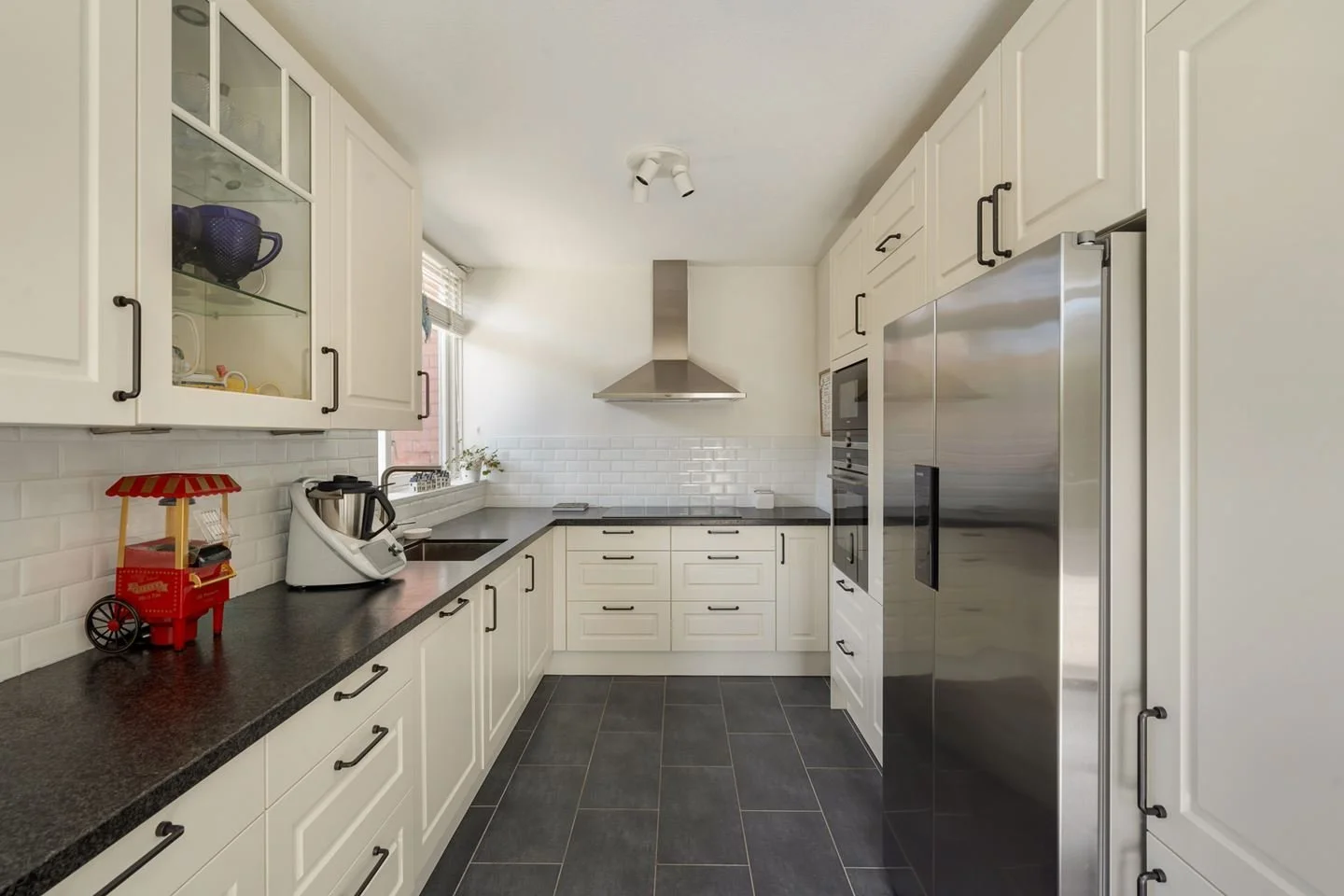 Modern outdoor living space with a swimming pool, lounge chairs, umbrella, and a seating area with cushions and a coffee table.