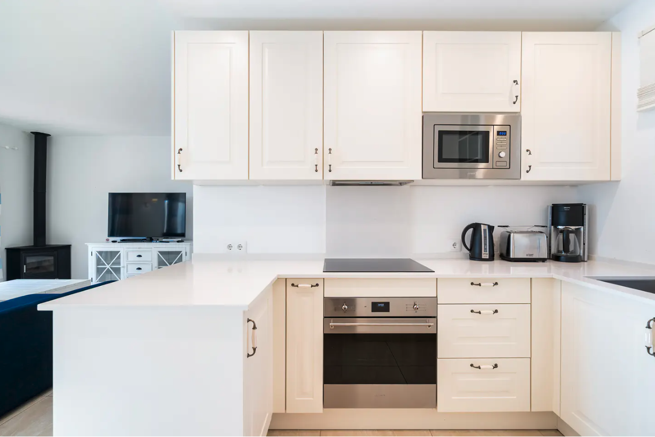 Modern outdoor living space with a swimming pool, lounge chairs, umbrella, and a seating area with cushions and a coffee table.