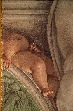 A baby lying on its stomach in a car seat, with a pacifier in its mouth.