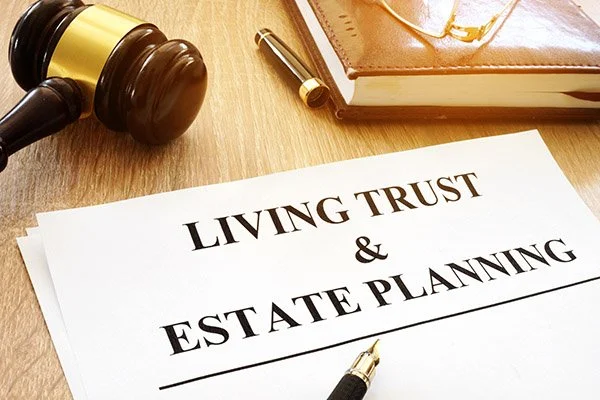 Gavel m upper left corner, in center on a white piece of paper are the words Living Trust & Estate Planning