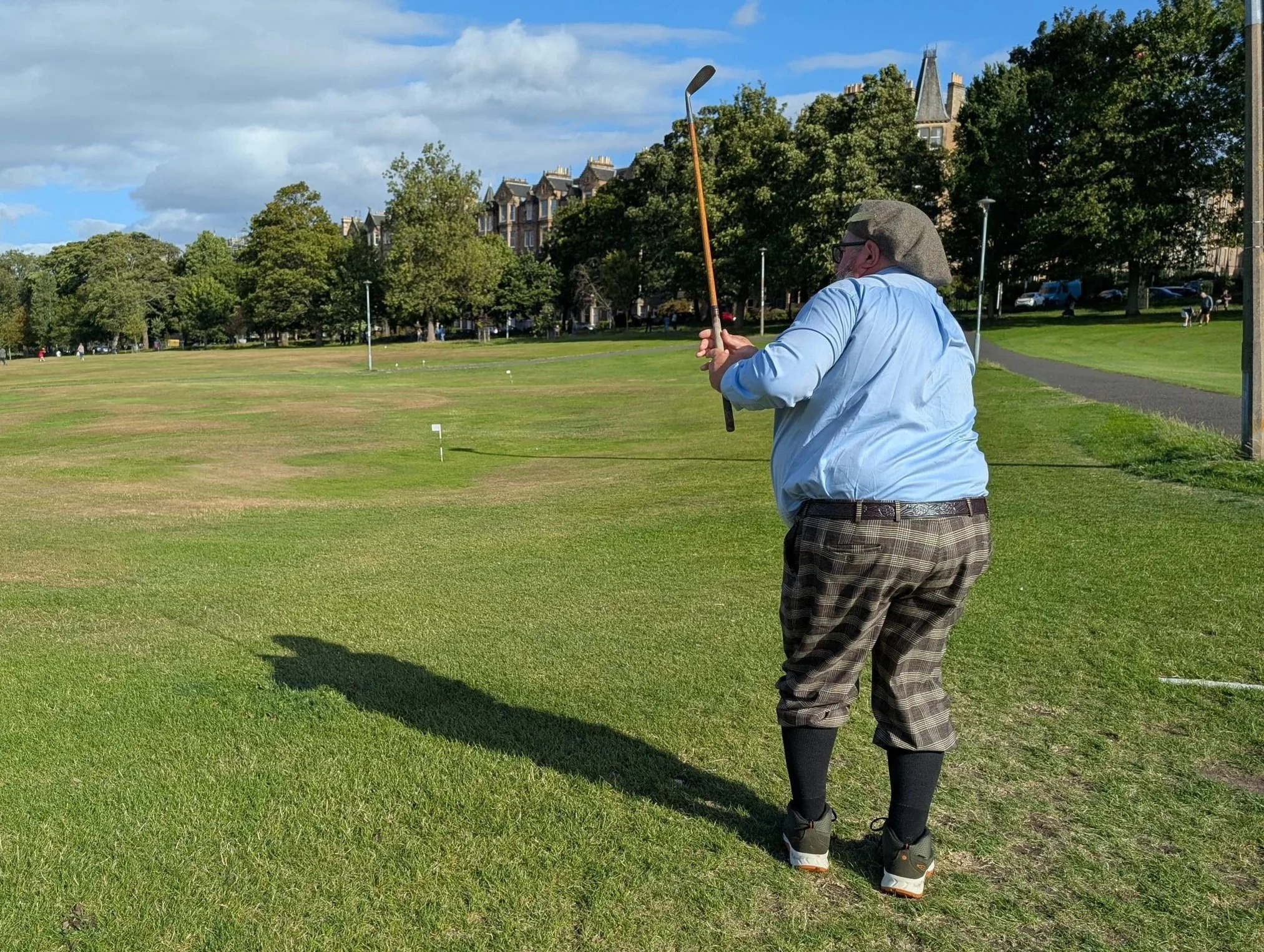 A golfer playing with a Groundhog Hickory Golf hickory golf club