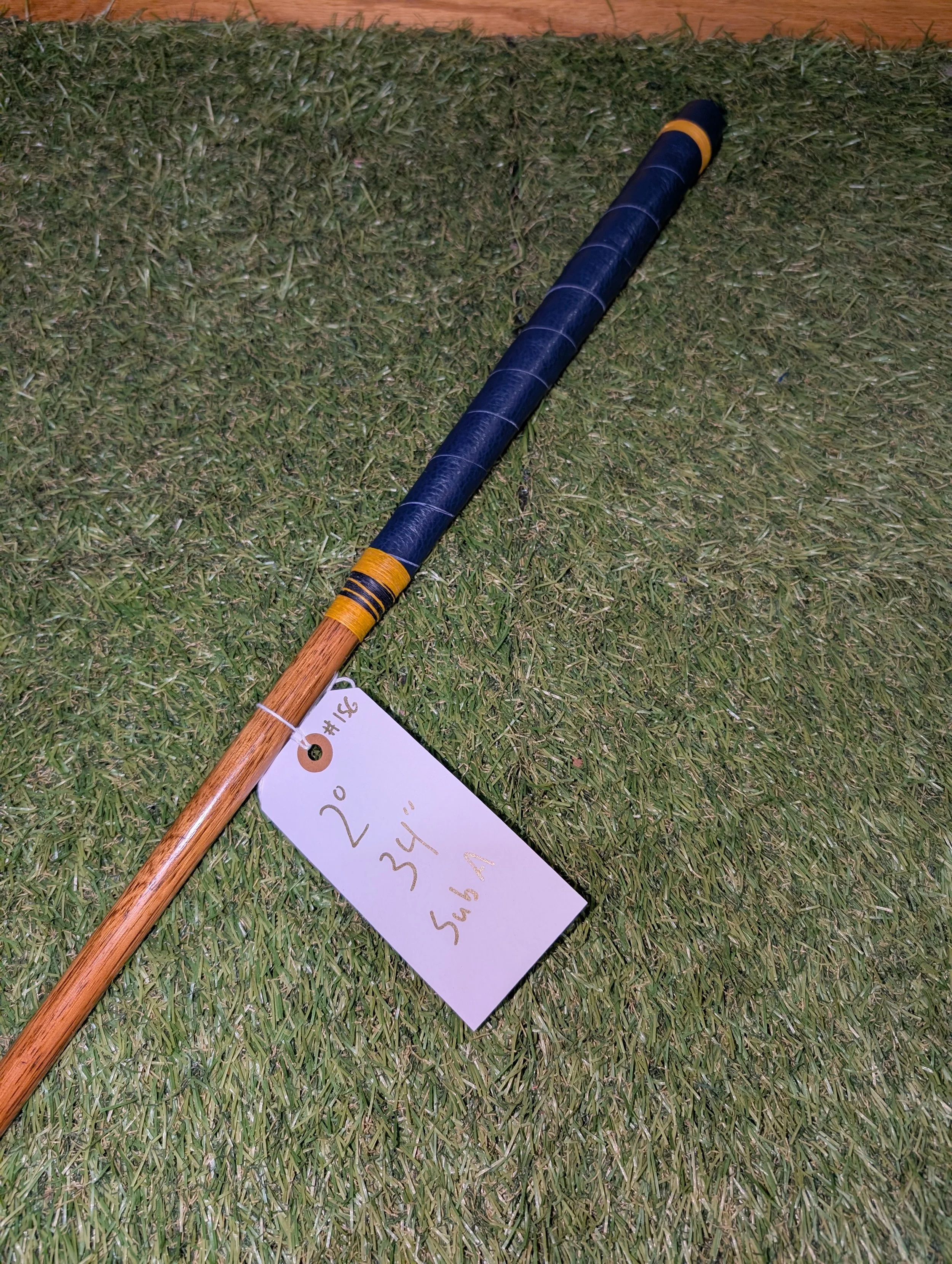 A hickory golf club putter with navy blue and gold decoration