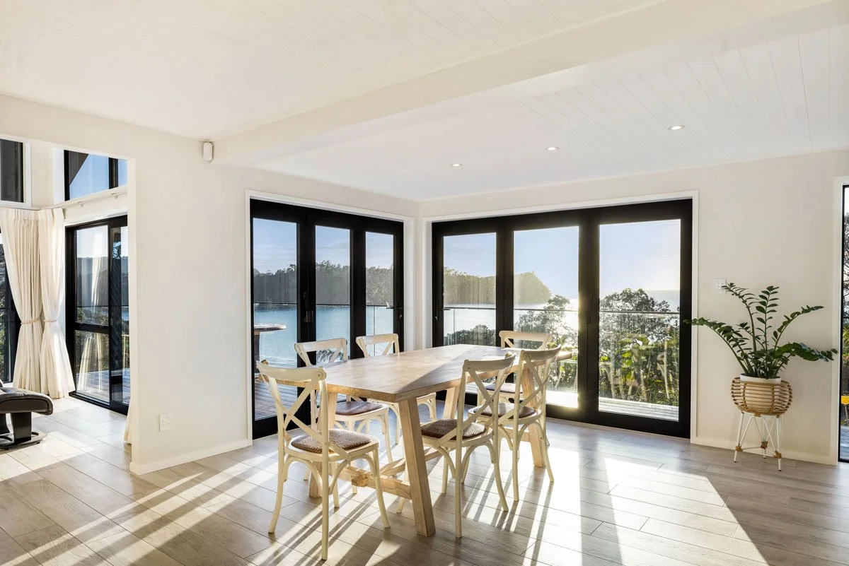 Renovated kitchen with natural oak floors and contrasting joinery in coastal North Auckland
