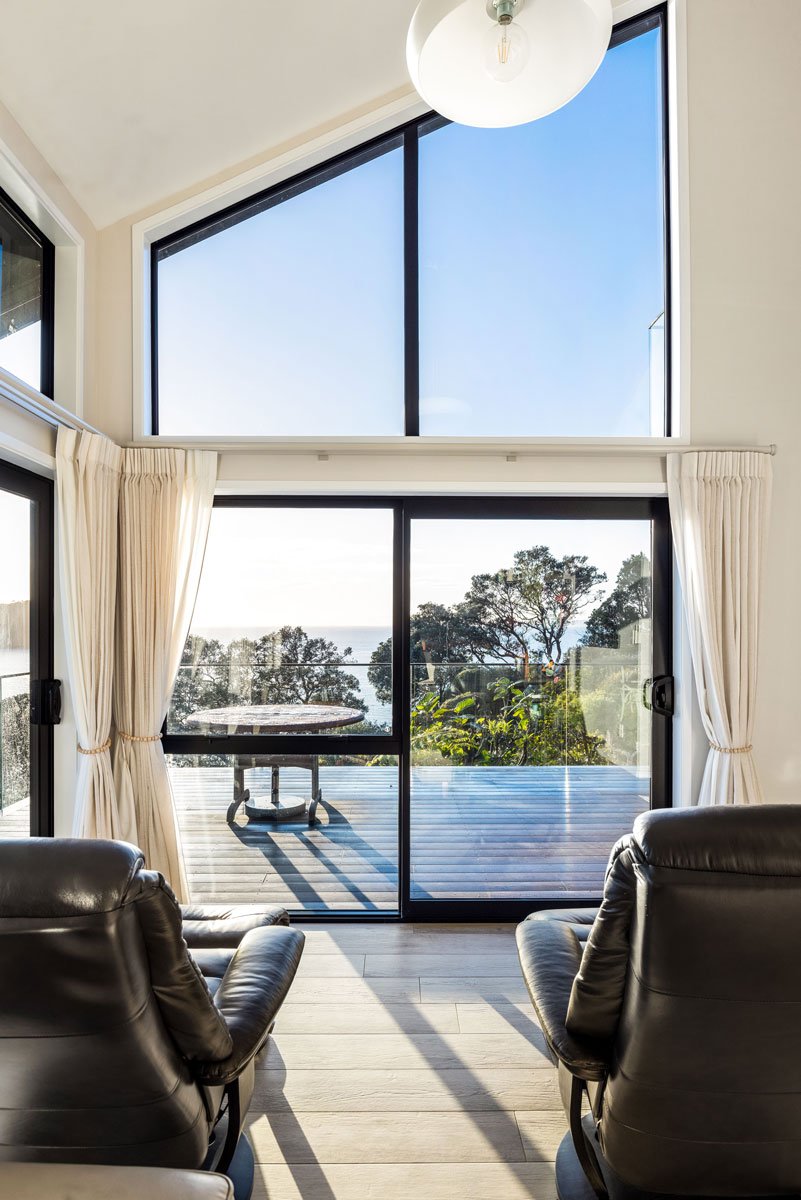 Renovated lounge with leather recliners and ocean-facing glass sliders in Hatfields Beach coastal retreat