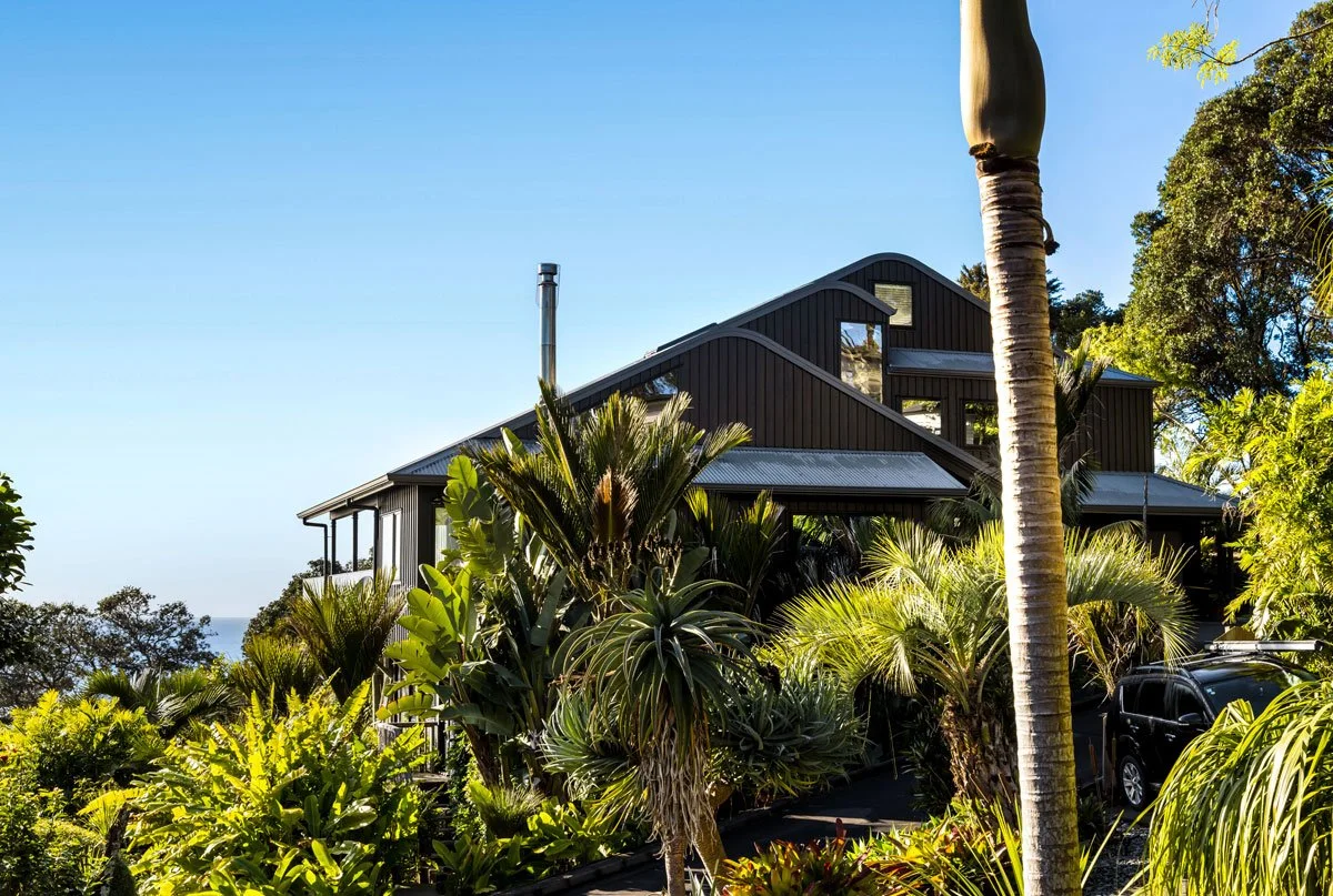 Wide view of multiple-tier decks with Kanda timber and modern glass balustrade details on a renovated home.
