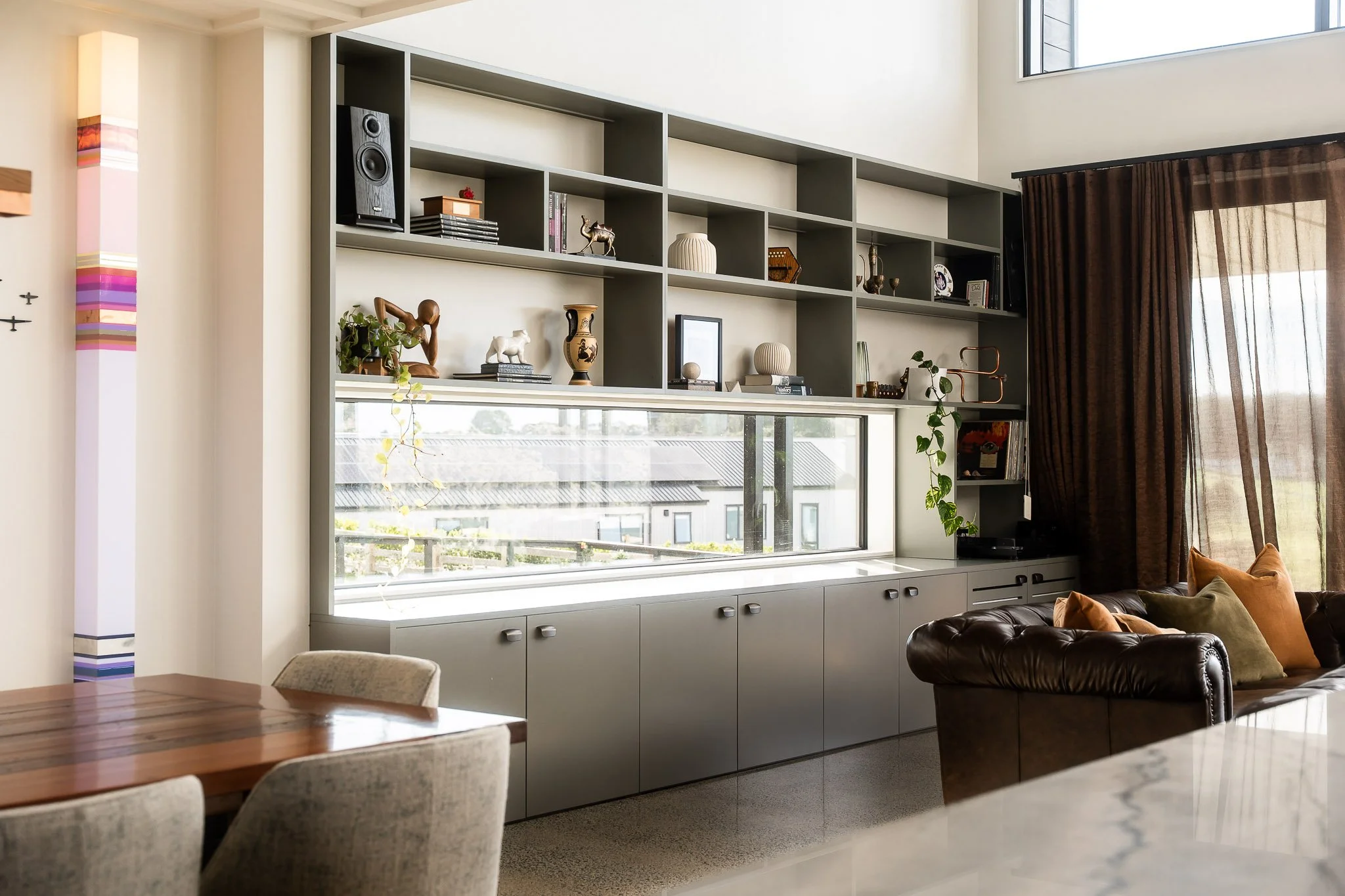 Home office nook cleverly integrated under gable window with natural light and timber desk unit.