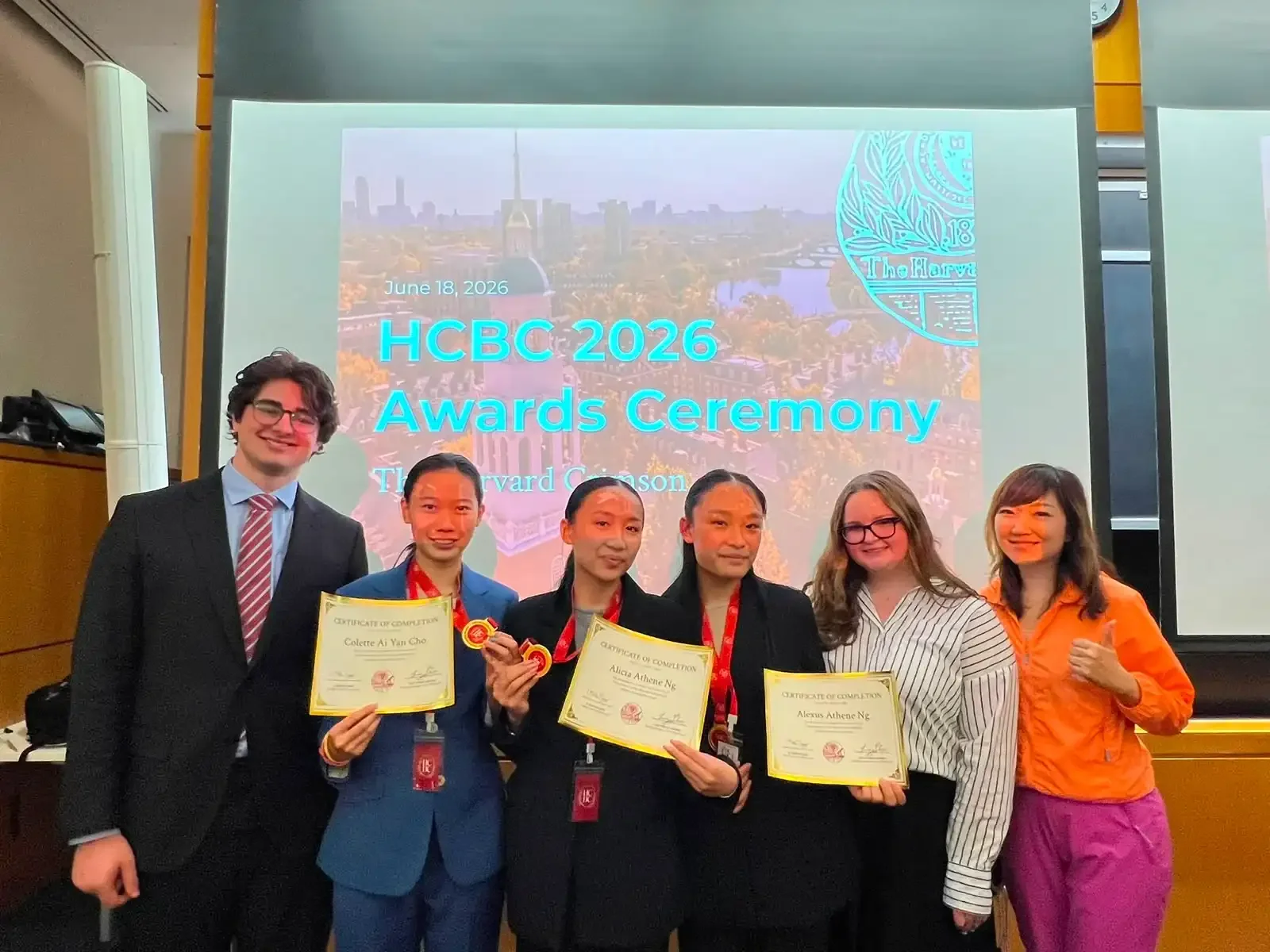 Winners holding certificates and medals at the Harvard Crimson Business Competition (HCBC) awards ceremony.