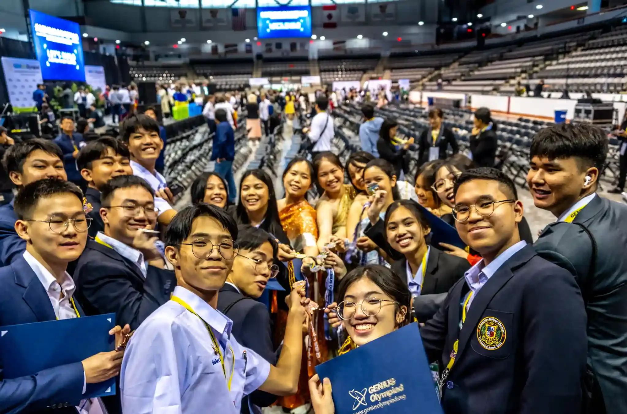 A group of high school students celebrating with medals and certificates at the Genius Olympiad Entrepreneurship competition.