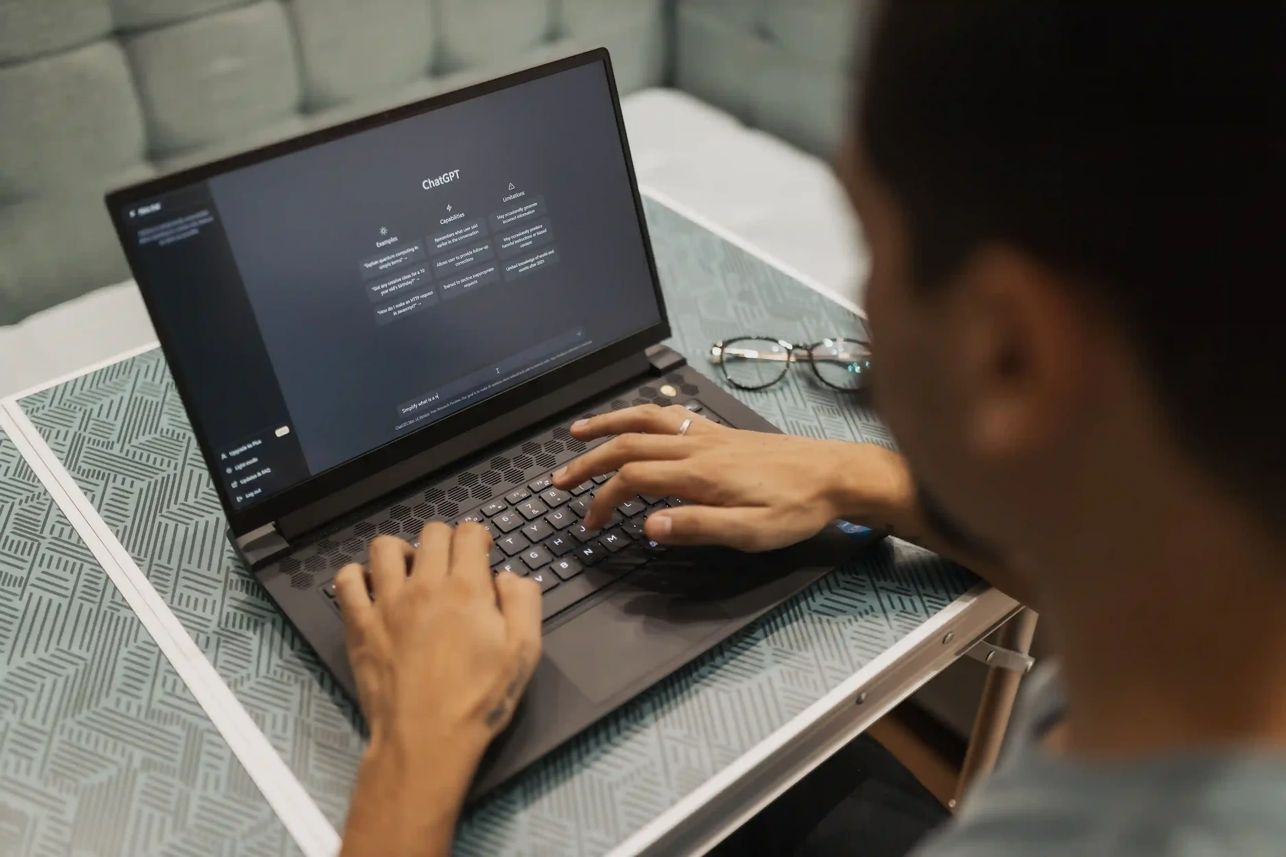 A professional typing on a laptop displaying the ChatGPT interface, illustrating the impact of artificial intelligence on entry-level jobs and career skill sets.