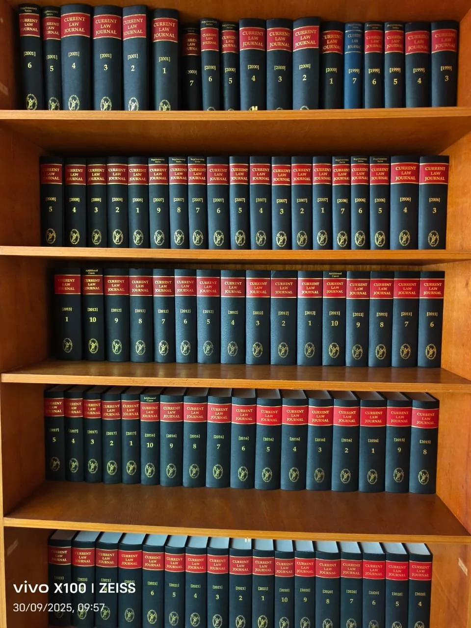 Bookshelves filled with multiple volumes of law journals titled "Current Law Journal" arranged by year from 1999 to 2021.