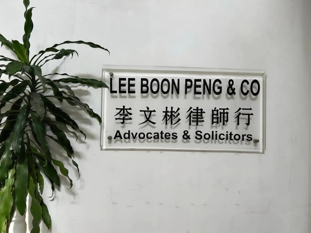 Sign for Lee Boon Peng & Co Advocates & Solicitors with Chinese characters and a plant on the left.